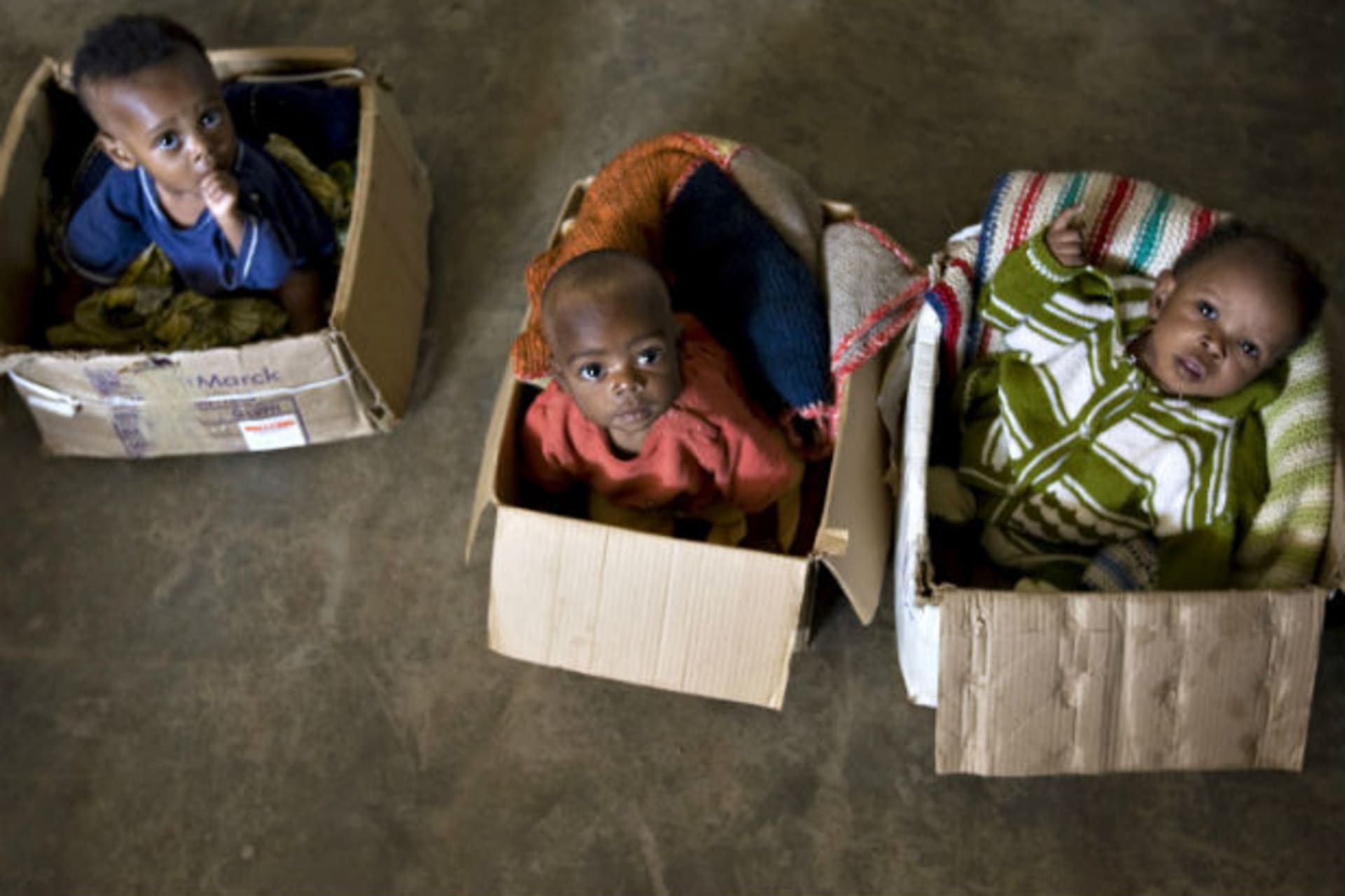 War-orphaned children sit in cardboard boxes at the Kizito orphanage in Bunia in northeastern Congo, February 24, 2009. (Finbarr O'Reilly/Courtesy Reuters)