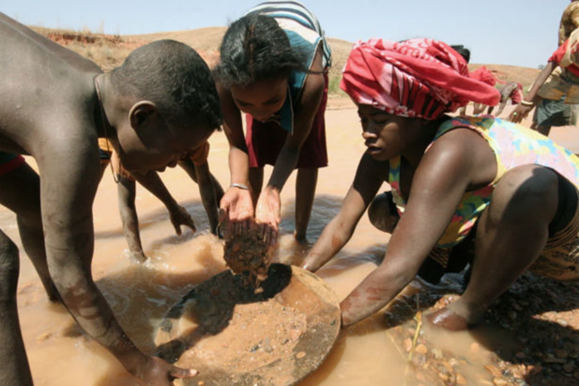 A woman and her children wash gravel from local mines in hope of finding sapphires in the town of Sakaraha 16/09/2007.