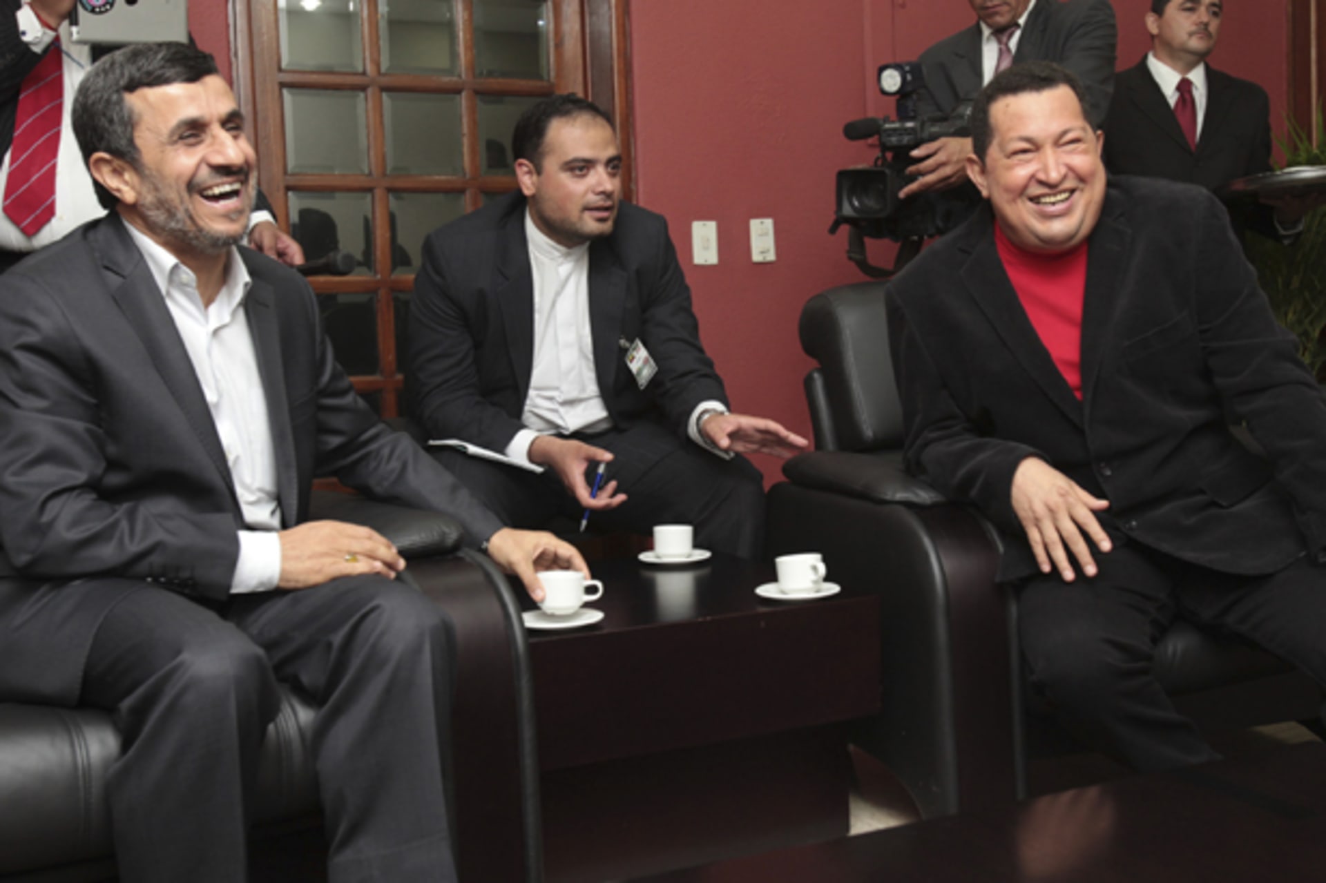 Venezuela's President Hugo Chavez and Iran's President Mahmoud Ahmadinejad laugh as they watch TV during a visit at Miraflores Palace in Caracas