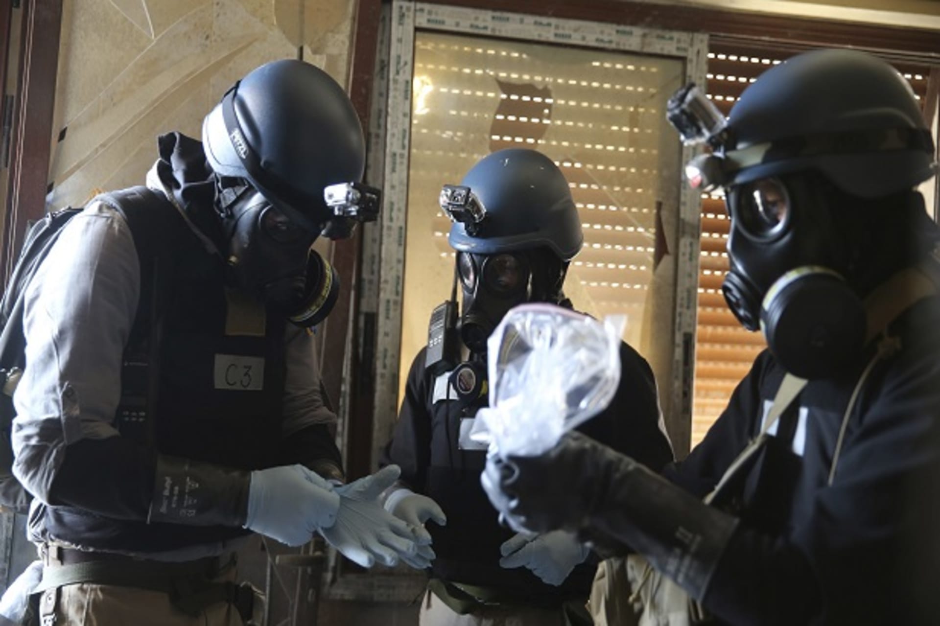 A U.N. chemical weapons expert holds a plastic bag containing samples from one of the sites of an alleged chemical weapons attack in Ain Tarma