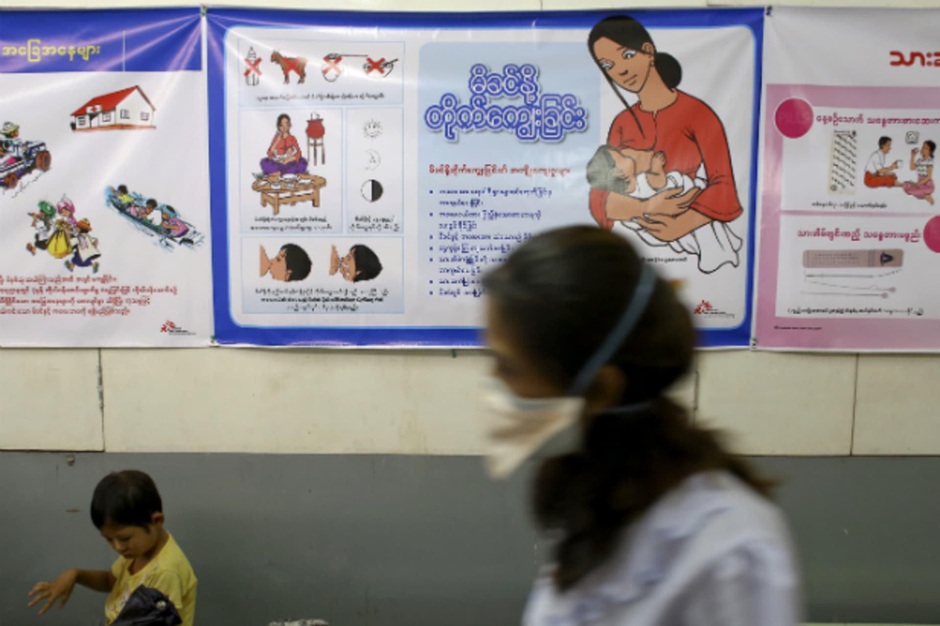 <p>A nurse walks past as a child sitting at Medecins Sans Frontieres Holland’s clinic in Yangon on March 3, 2014. (Minzayar Minzayar/Courtesy Reuters)</p>
