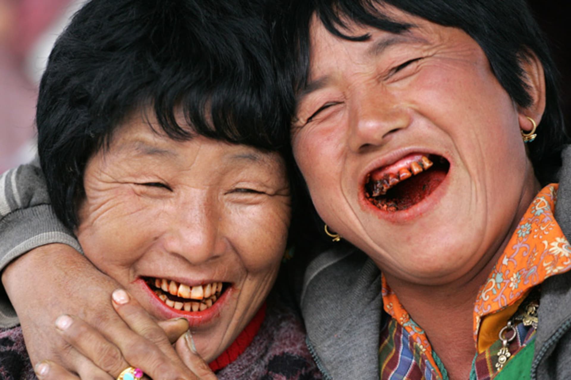 Women, their teeth red from chewing betel nuts, laugh at a vegetable market in Bhutanese capital Thimpu, October 23, 2006 (Gopal Chitrakar/Courtesy Reuters).