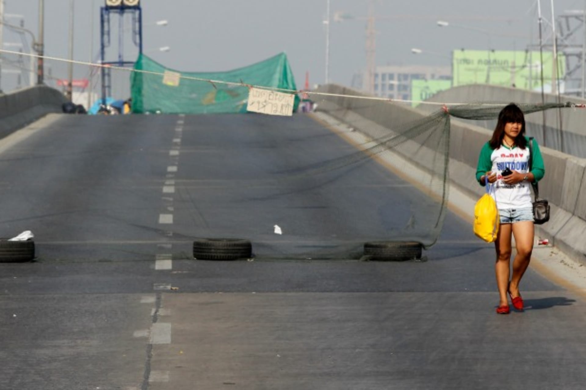 <p>An anti-government protester walks down an empty road during a rally near the Government Complex in Bangkok on January 24, 2014. (Chaiwat Subprasom/Courtesy Reuters)</p>
