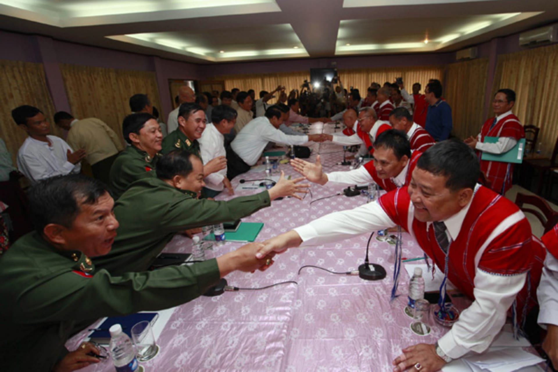 <p>Representatives from Myanmar’s government and the Karen National Union (KNU) shake hands during peace talks at Hotel Zwekabin in Pa-an, capital of the Karen State in eastern Myanmar January 12, 2012.</p>
