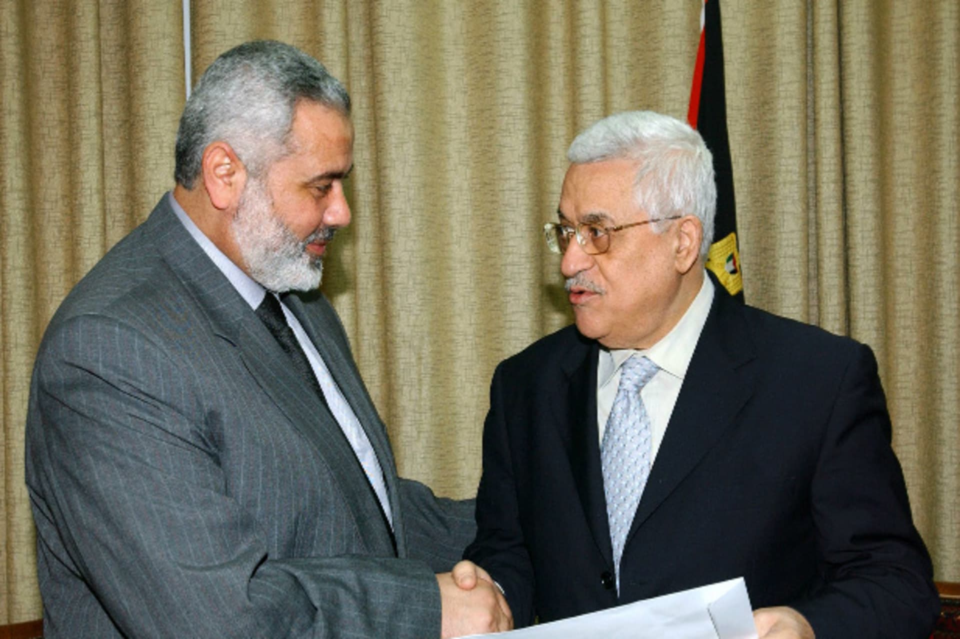 Palestinian prime minister Ismail Haniyeh shakes hands with President Mahmoud Abbas after handing him an agreed list of ministers for a new unity government, in Gaza March 15, 2007 in this picture released by the Palestinian Press Office (PPO)