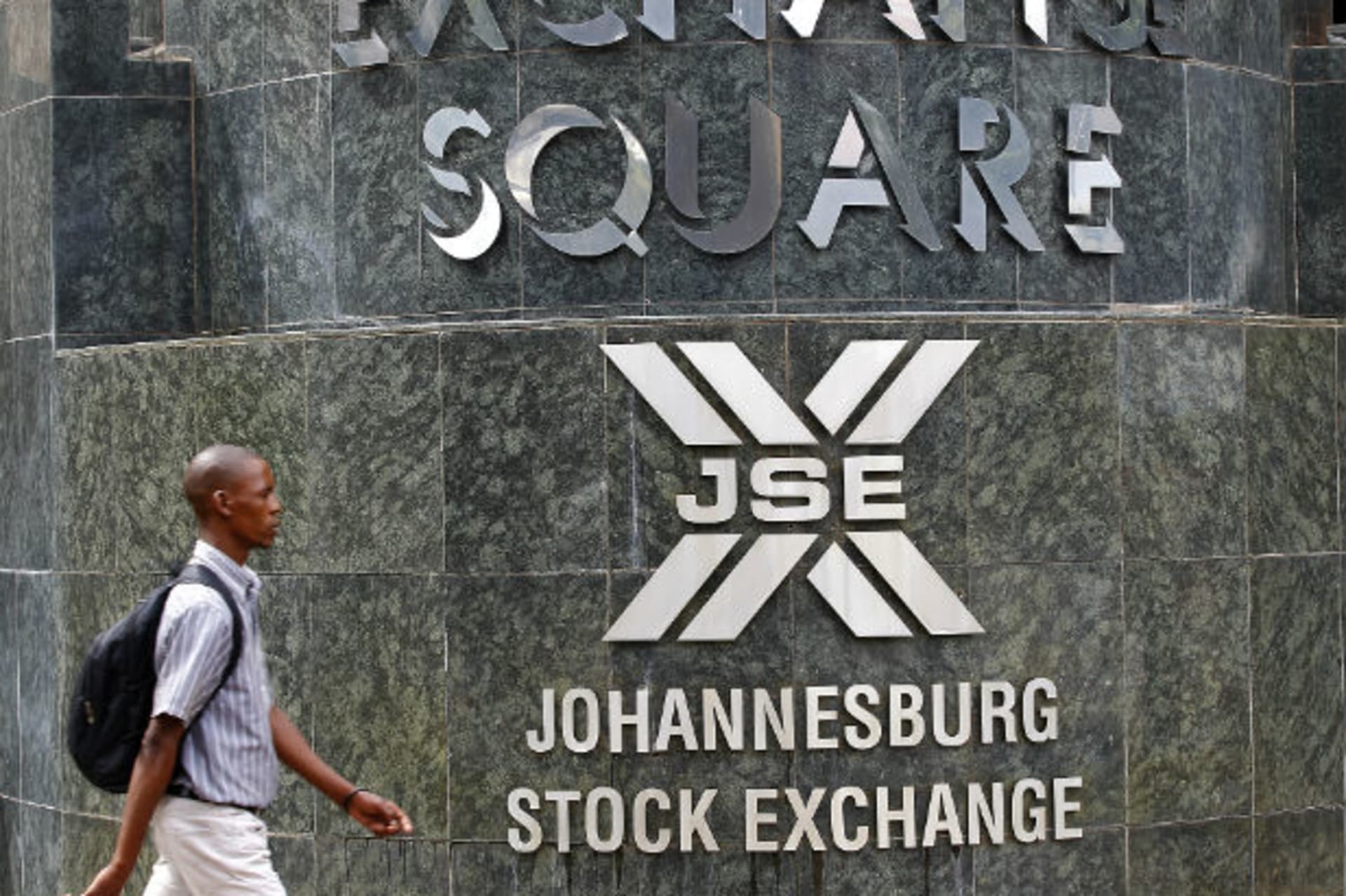 A man walks past the Johannesburg Stock Exchange building in Sandton December 6, 2012.