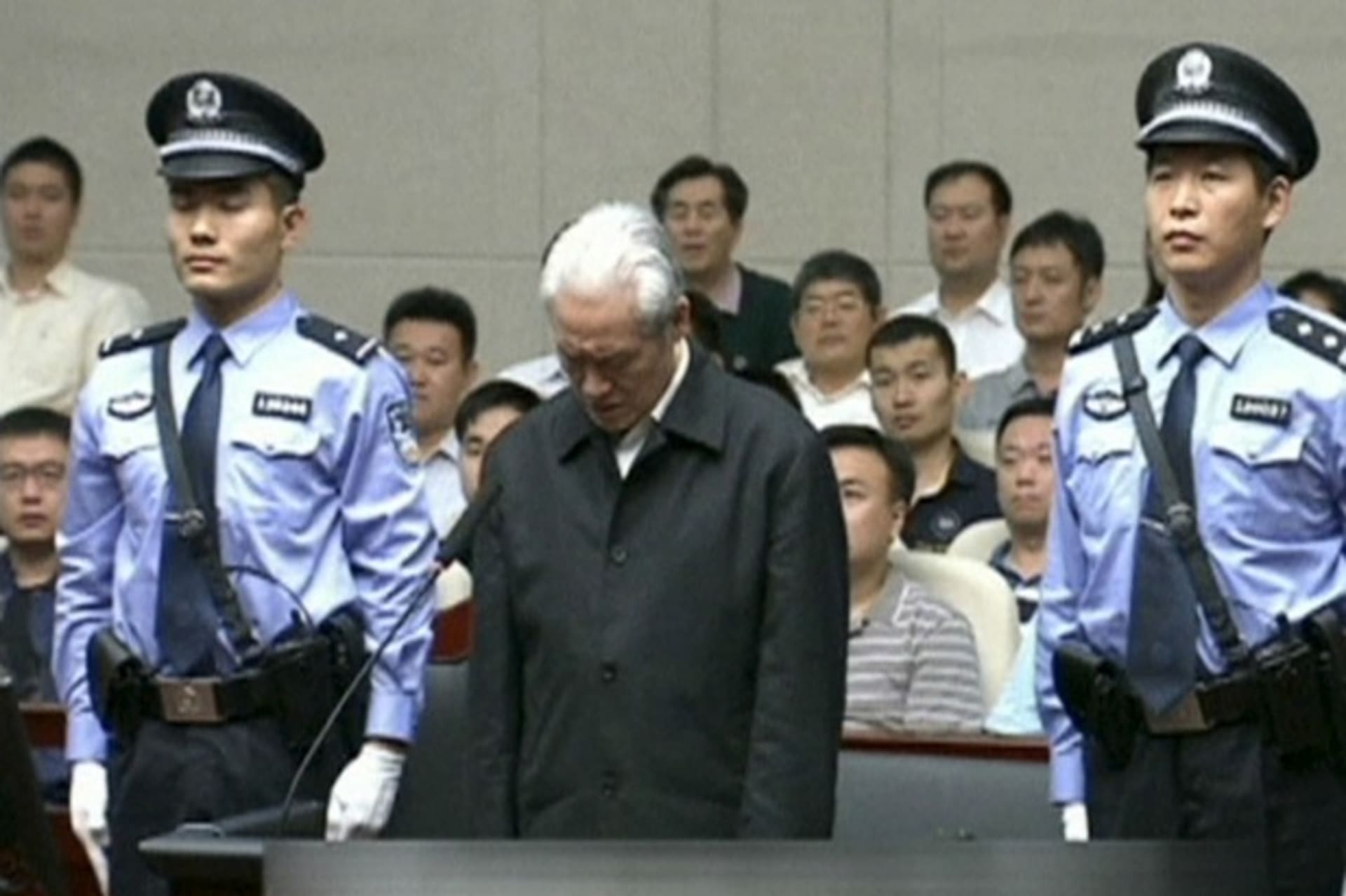 <p>Zhou Yongkang, China’s former domestic security chief, stands between his police escorts as he listens to his sentence in a co…’s Court ruled in its first instance. Zhou pleaded guilty and will not appeal. REUTERS/China Central Television via REUTERS TV</p>
