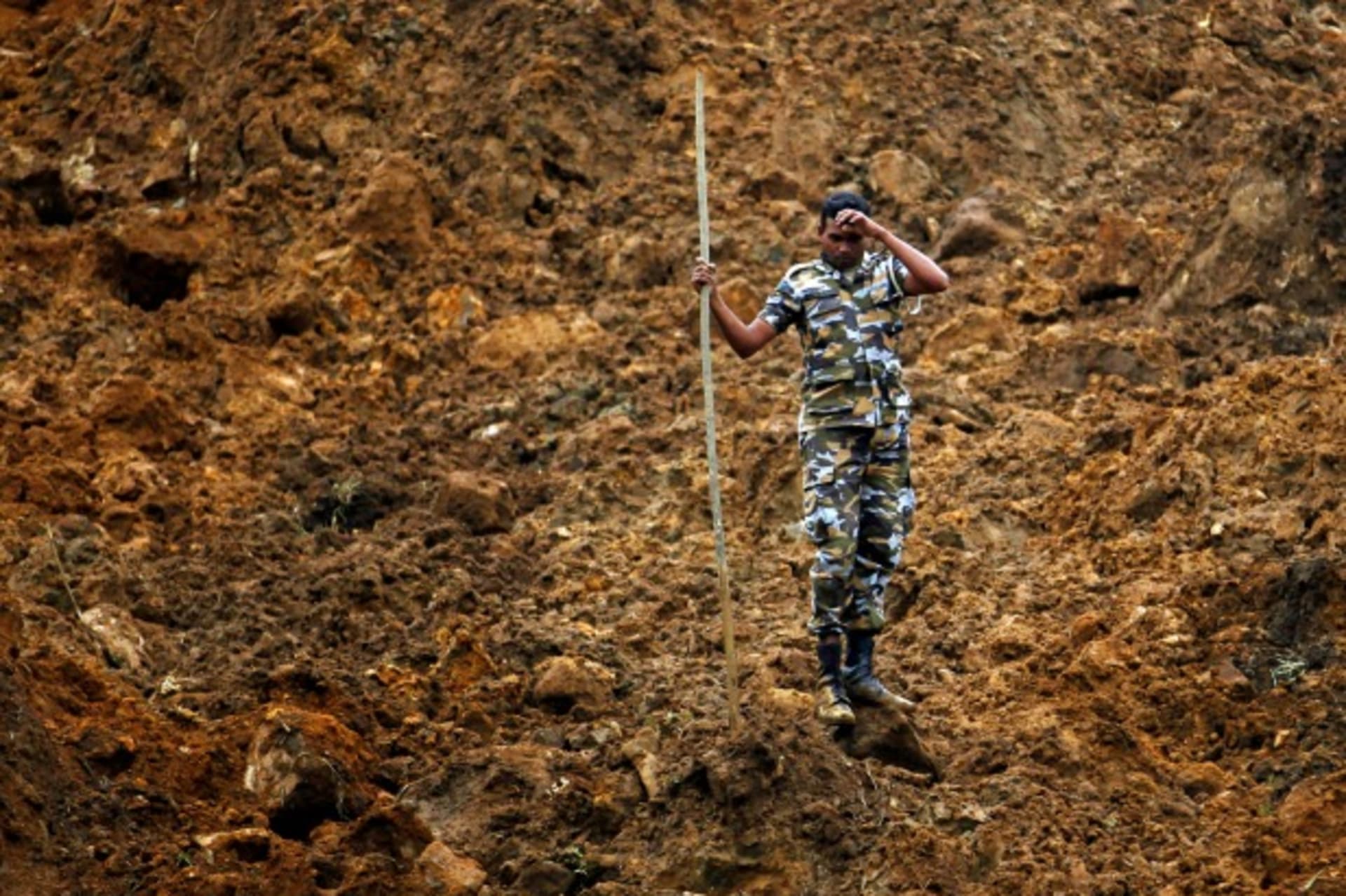 <p>A member of a military rescue team pauses during search operations at the site of a landslide at the Koslanda tea plantation near Haldummulla on October 30, 2014. (Dinuka Liyanawatte/Courtesy Reuters)</p>
