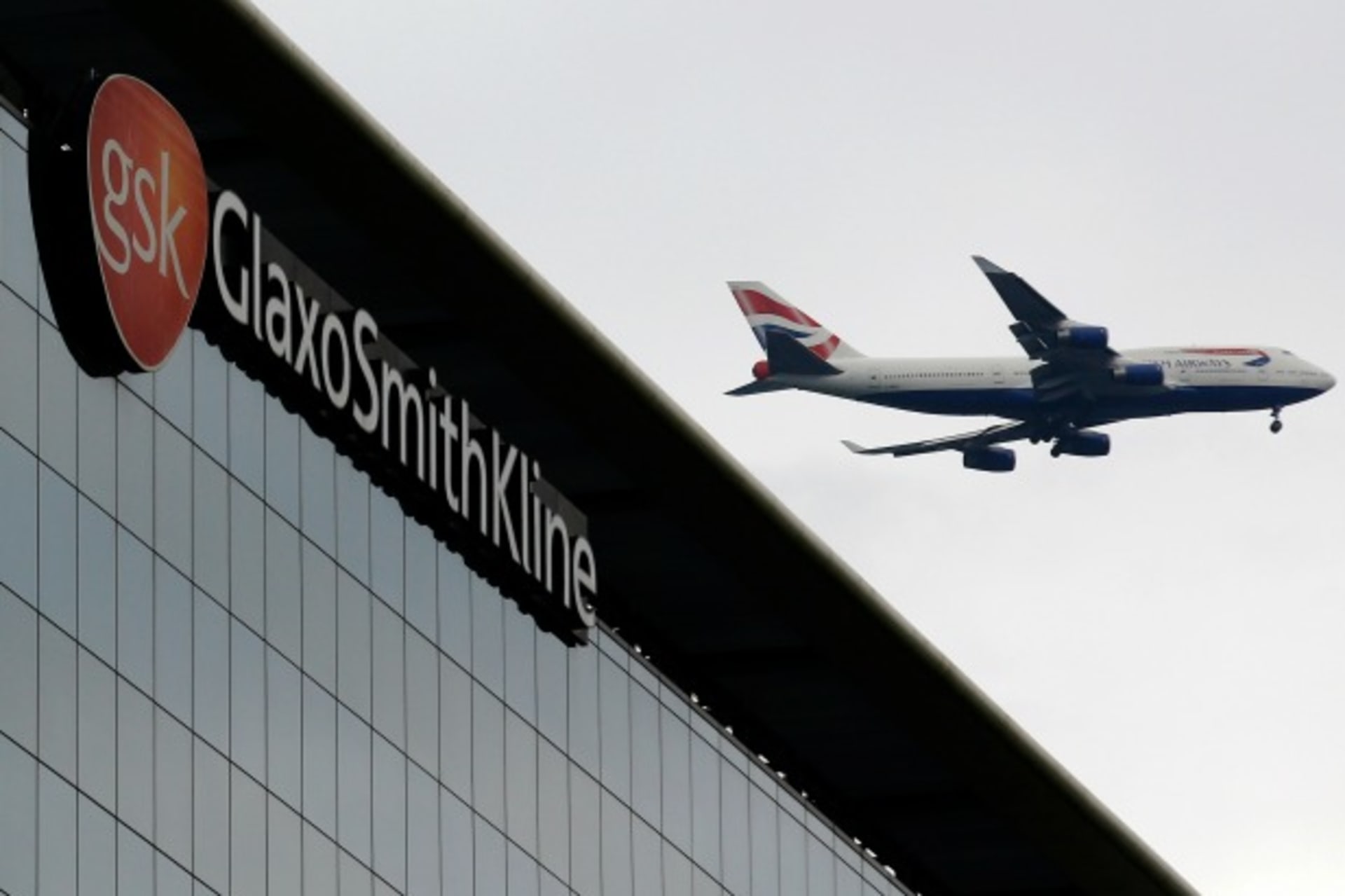 <p>A British Airways airplane flies past a signage for pharmaceutical giant GlaxoSmithKline (GSK) in London on April 22, 2014. (Luke MacGregor/Courtesy Reuters)</p>
