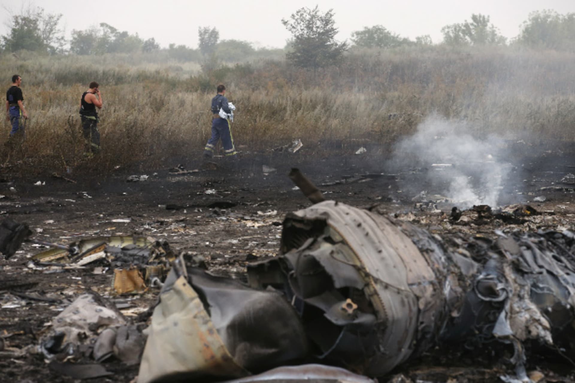 <p>Emergencies ministry members walk at the site of a Malaysia Airlines Boeing 777 plane crash near the settlement of Grabovo in the Donetsk region on July 17, 2014 (Maxim Zmeyev/Courtesy: Reuters).</p>
