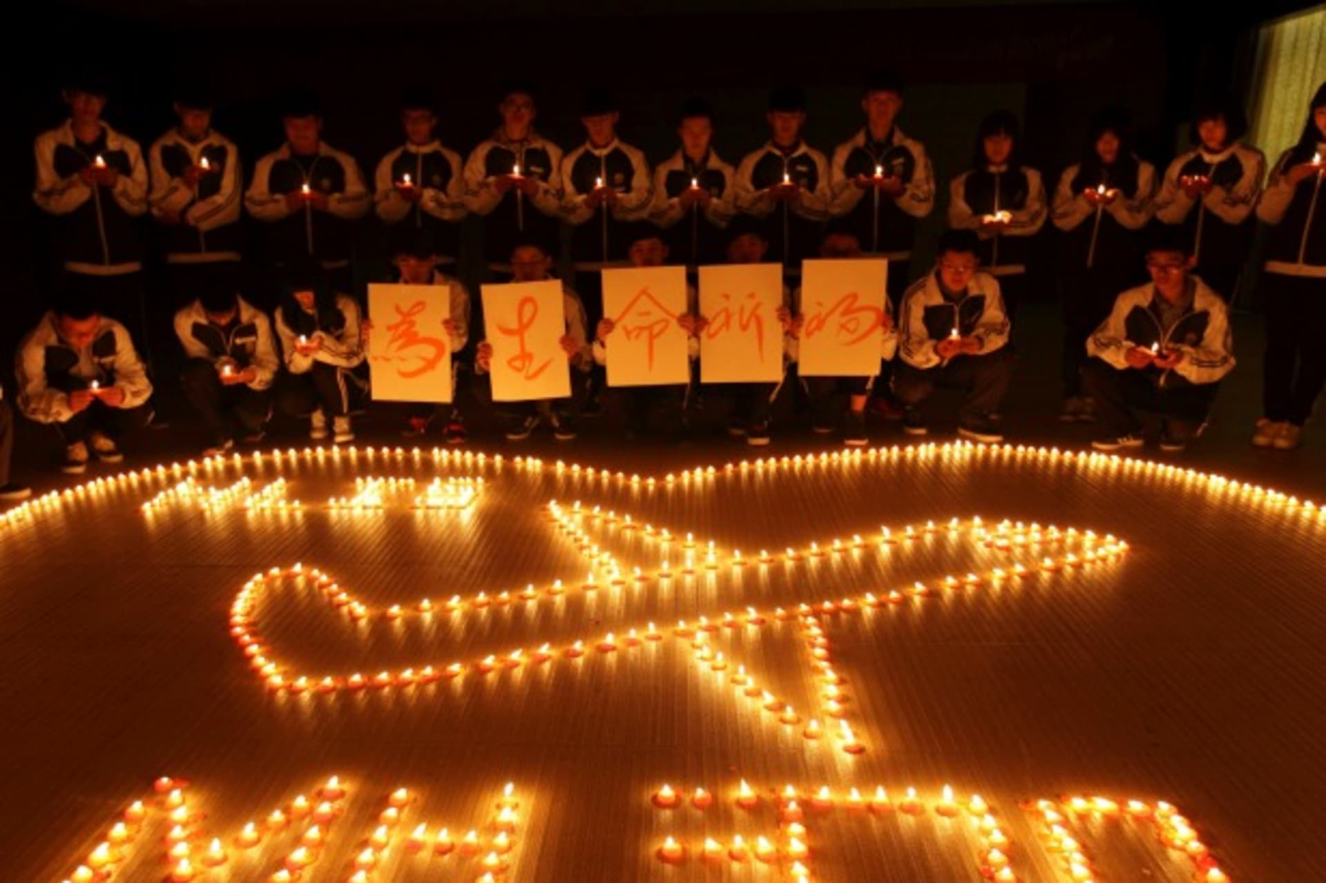 <p>International school students light candles to pray for passengers aboard Malaysia Airlines flight MH370, in Zhuji, Zhejiang province, on March 10, 2014. (Stringer/Courtesy Reuters)</p>
