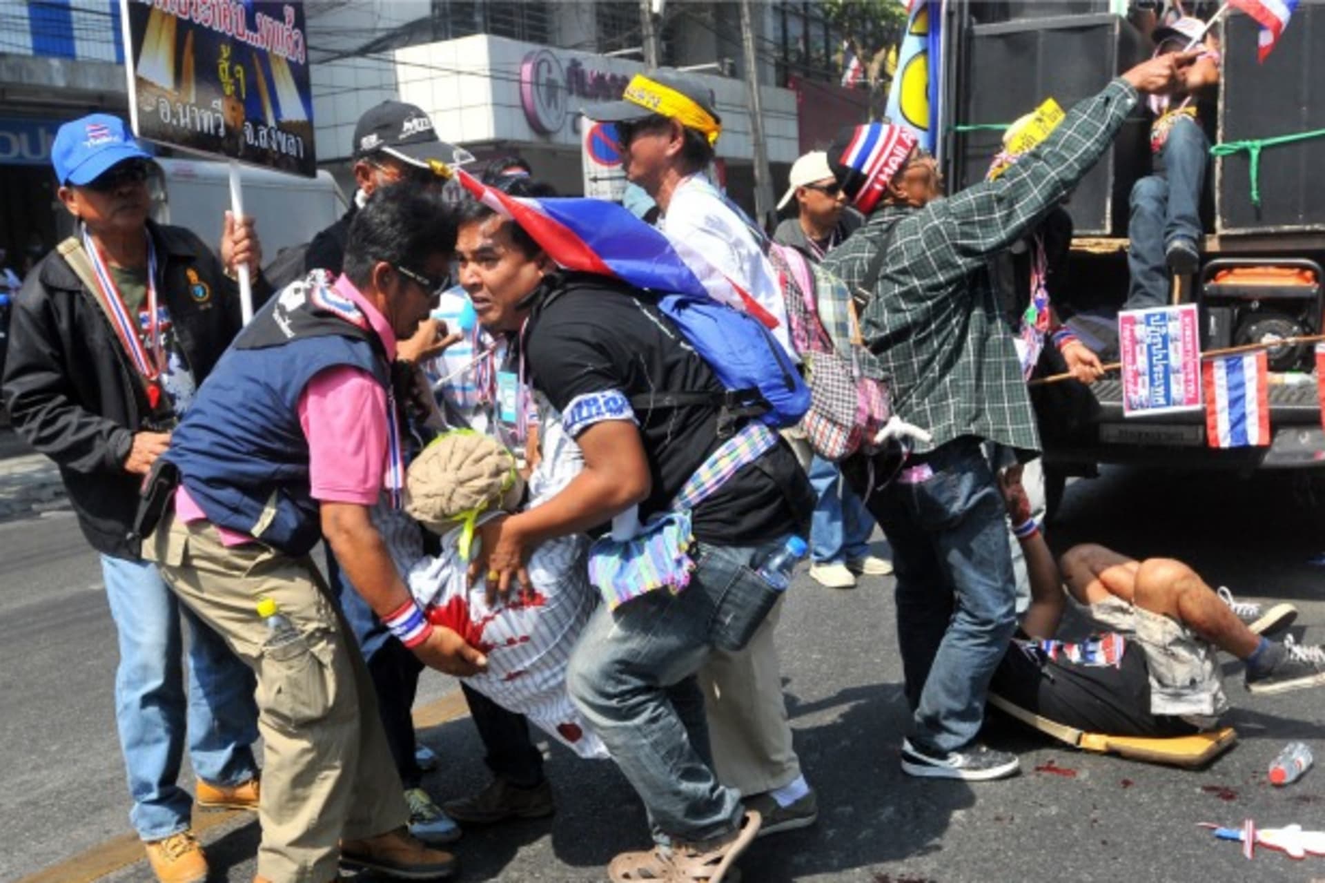 <p>Anti-government protesters help a fellow protester injured in a grenade attack during a rally in Bangkok on January 17, 2014. (Stringer/Courtesy Reuters)</p>
