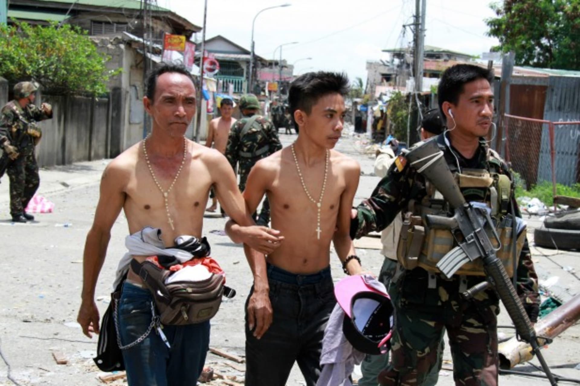 <p>Government soldiers escort residents who were taken hostage and used as human shields by Muslim rebels of Moro National Libera…ighting with government soldiers, in Zamboanga city in southern Philippines on September 17, 2013. (Stringer/Courtesy Reuters)</p>
