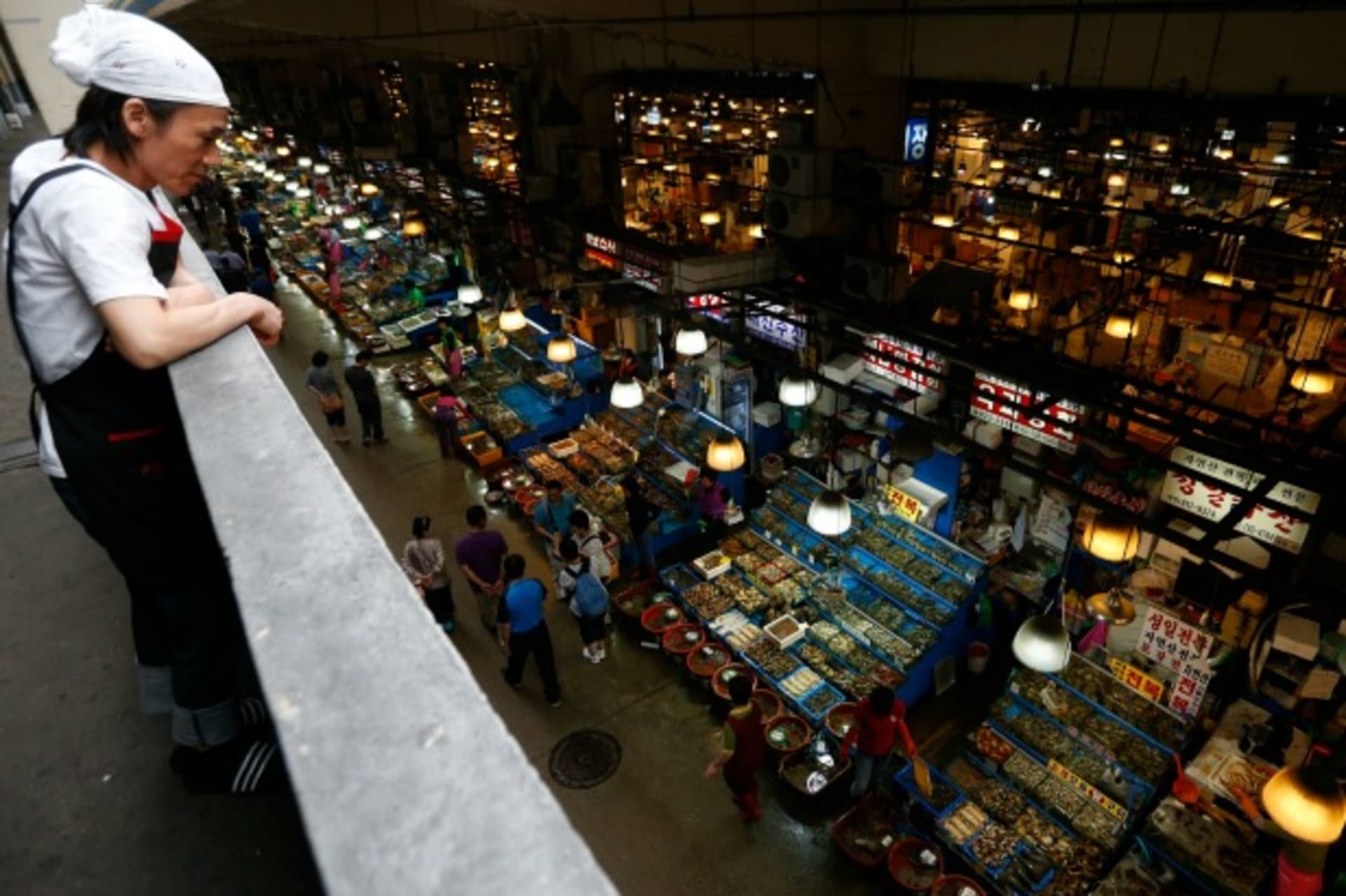 <p>An employee of a sushi restaurant takes a break as seafood stalls are seen at the Noryangjin fisheries wholesale market in Seoul on September 6, 2013. (Kim Hong-Ji/Courtesy Reuters)</p>
