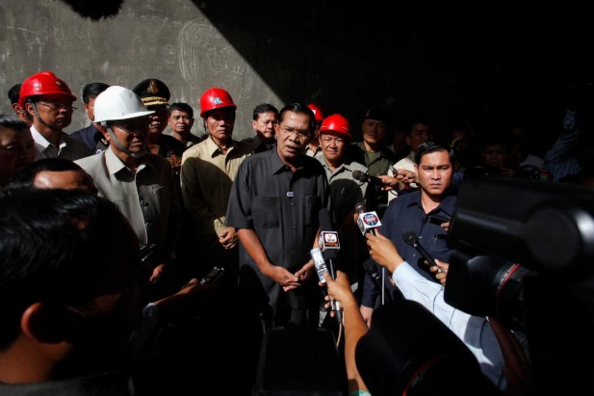 Cambodia's Prime Minister Hun Sen (C) speaks to the media as he inspects a bridge construction site in Phnom Penh on July 31, 2013.