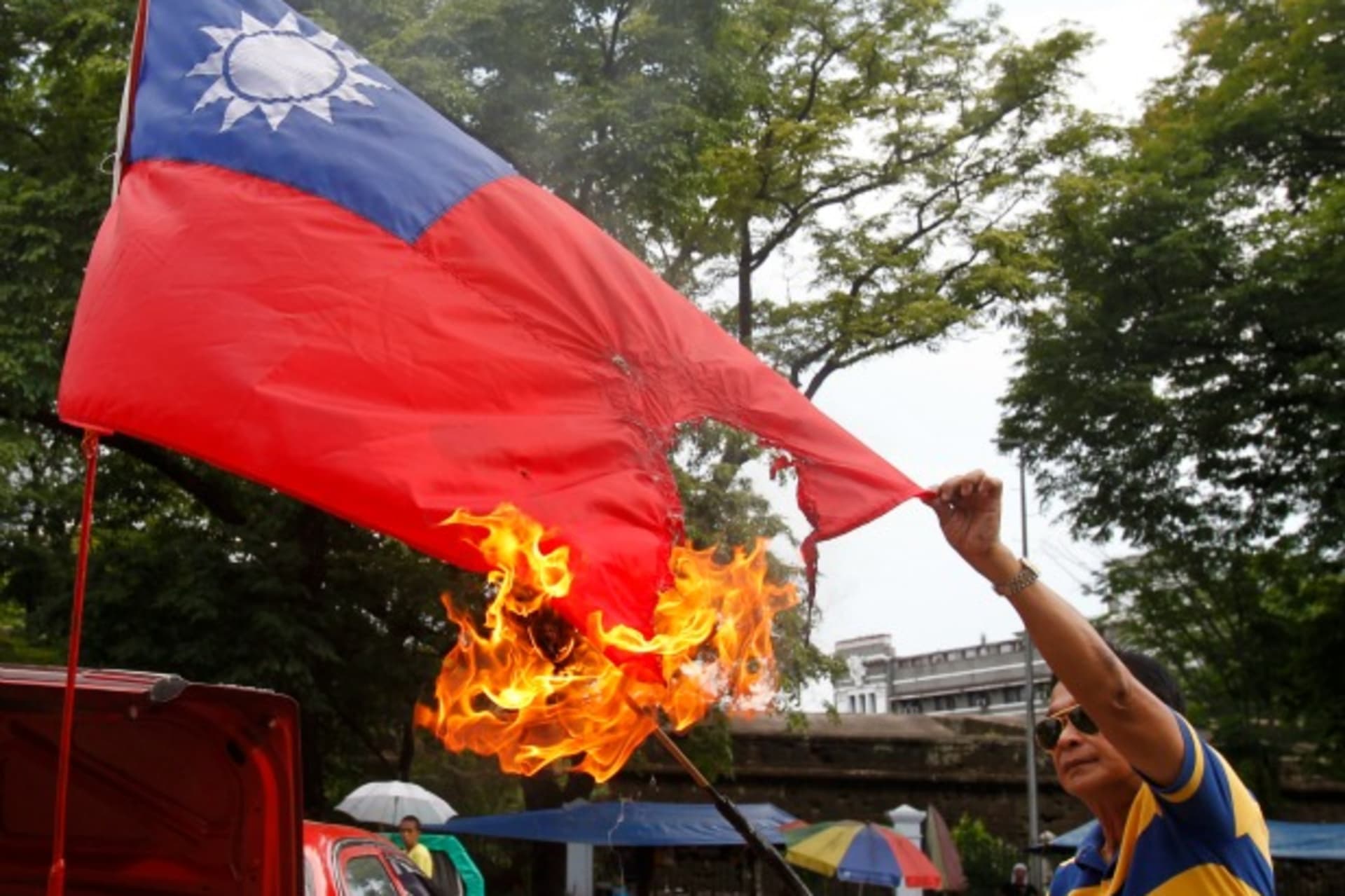 <p>Former police officer Abner Afuang burns a replica of Taiwan’s national flag as he protests against the mistreatment of Filipinos working overseas, along a main street of Manila on May 17, 2013. (Courtesy Reuters/Romeo Ranoco)</p>
