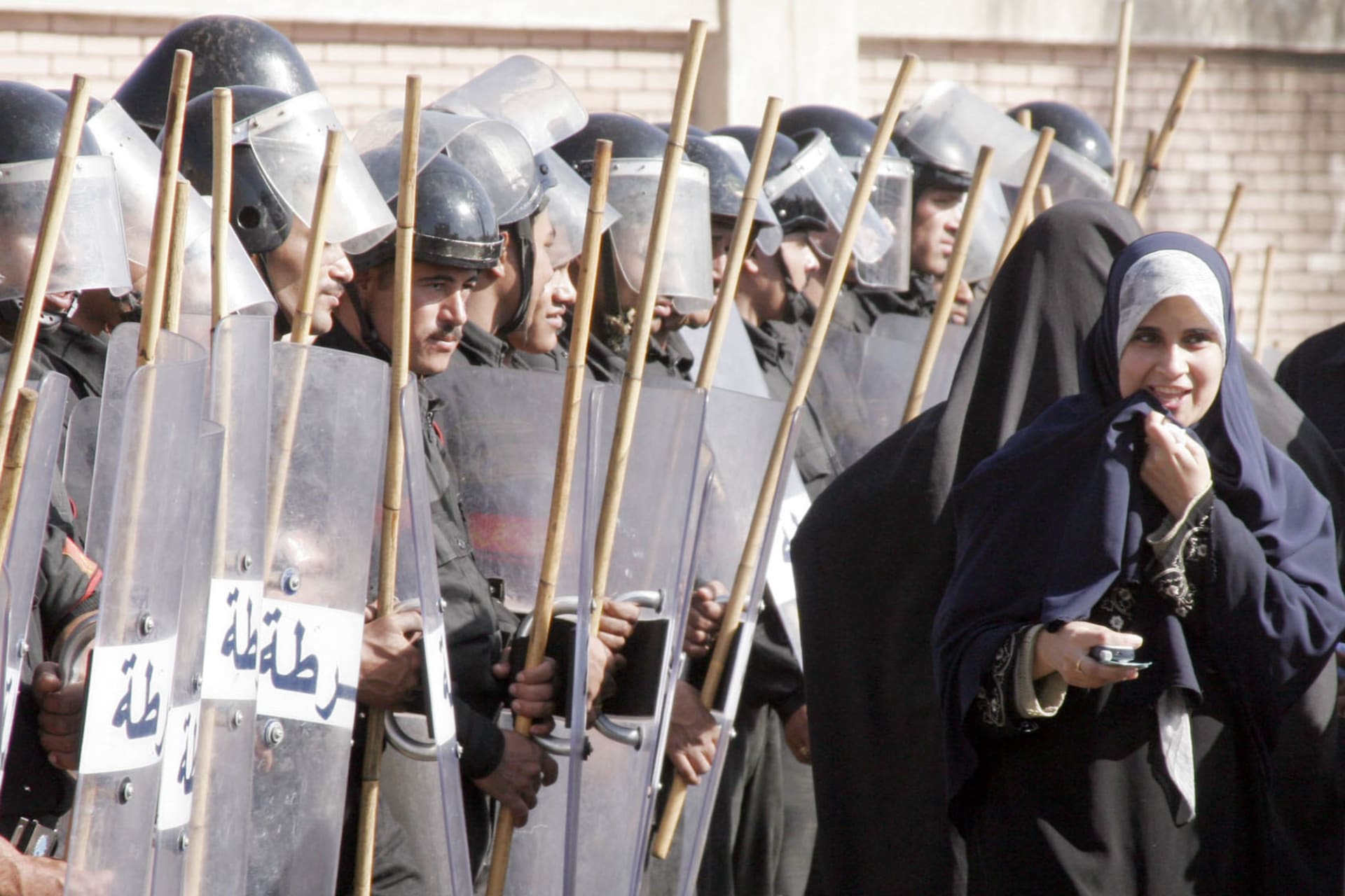 <p>Egyptian supporters of the Muslim brotherhood react in front of anti-riot police blocking the way to a polling station in Al Mansoura, north of Cairo, Egypt, on Thursday, Dec. 1, 2005.</p>
