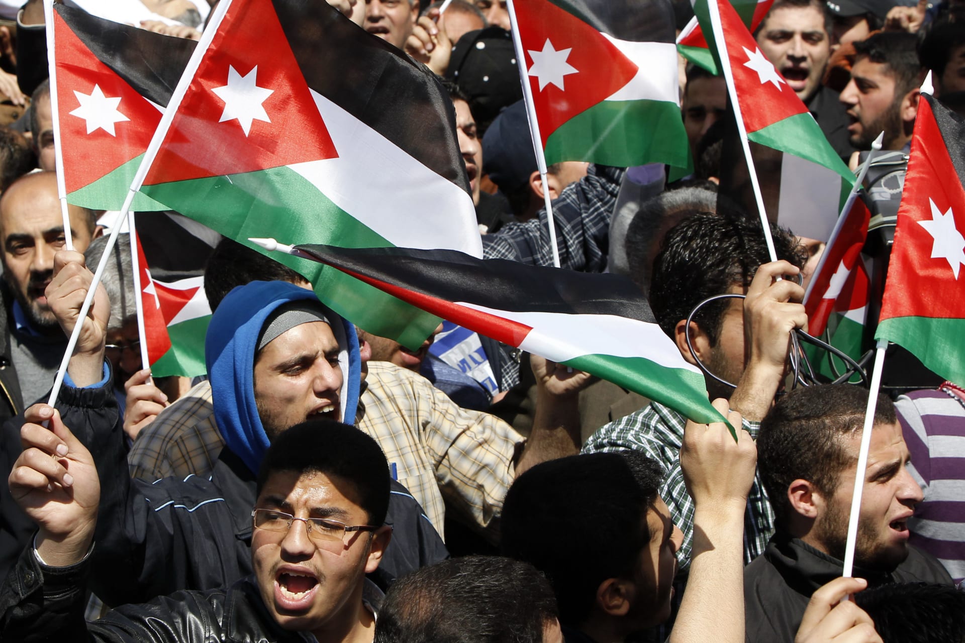 <p>Demonstrators wave Jordanian national flags and shout anti-government slogans during the funeral of Saad Khairy in Amman on March 27, 2011.</p>
