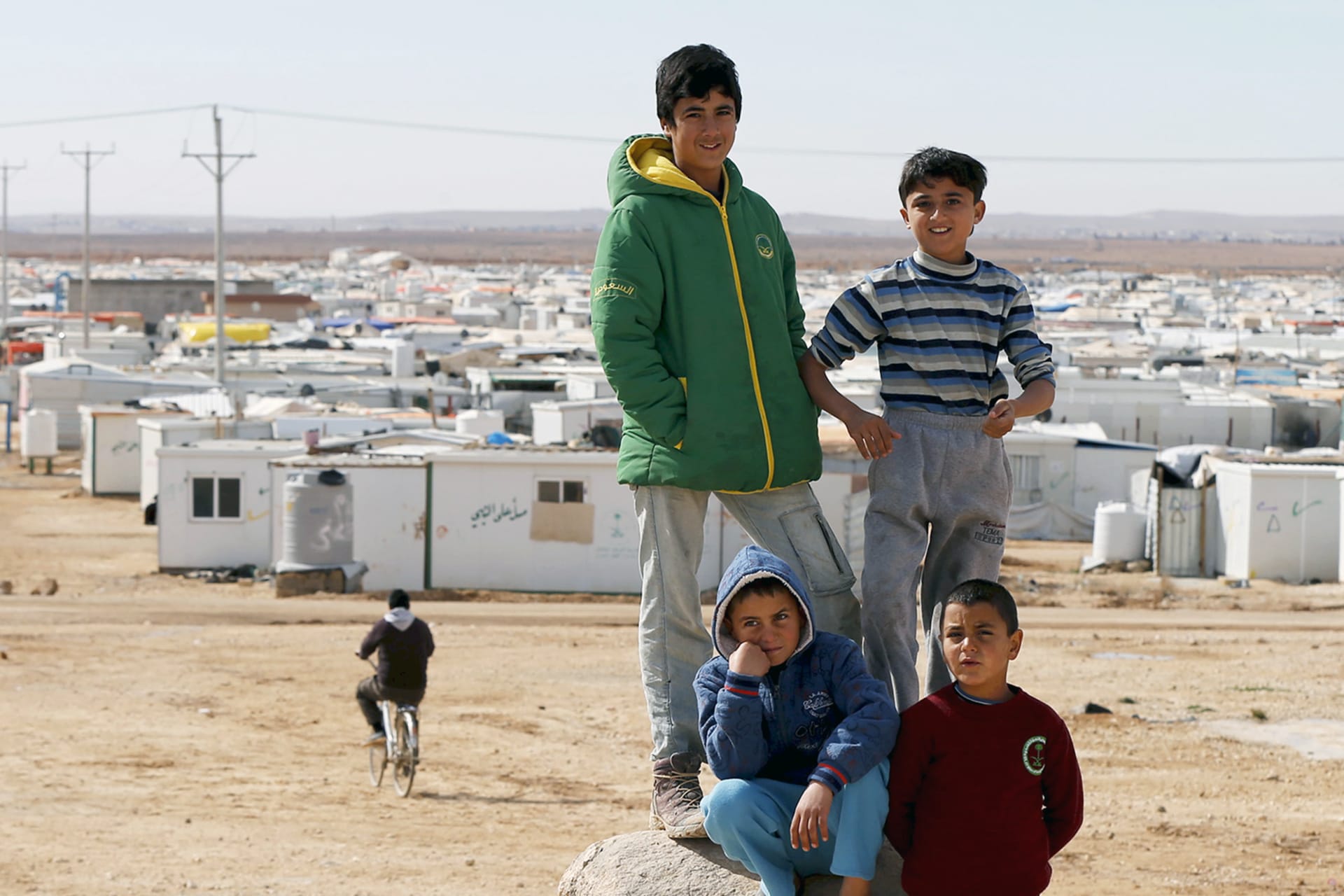 <p>Syrian refugee children standing on a rock in Al Zaatari refugee camp in the Jordanian city of Mafraq.</p>
