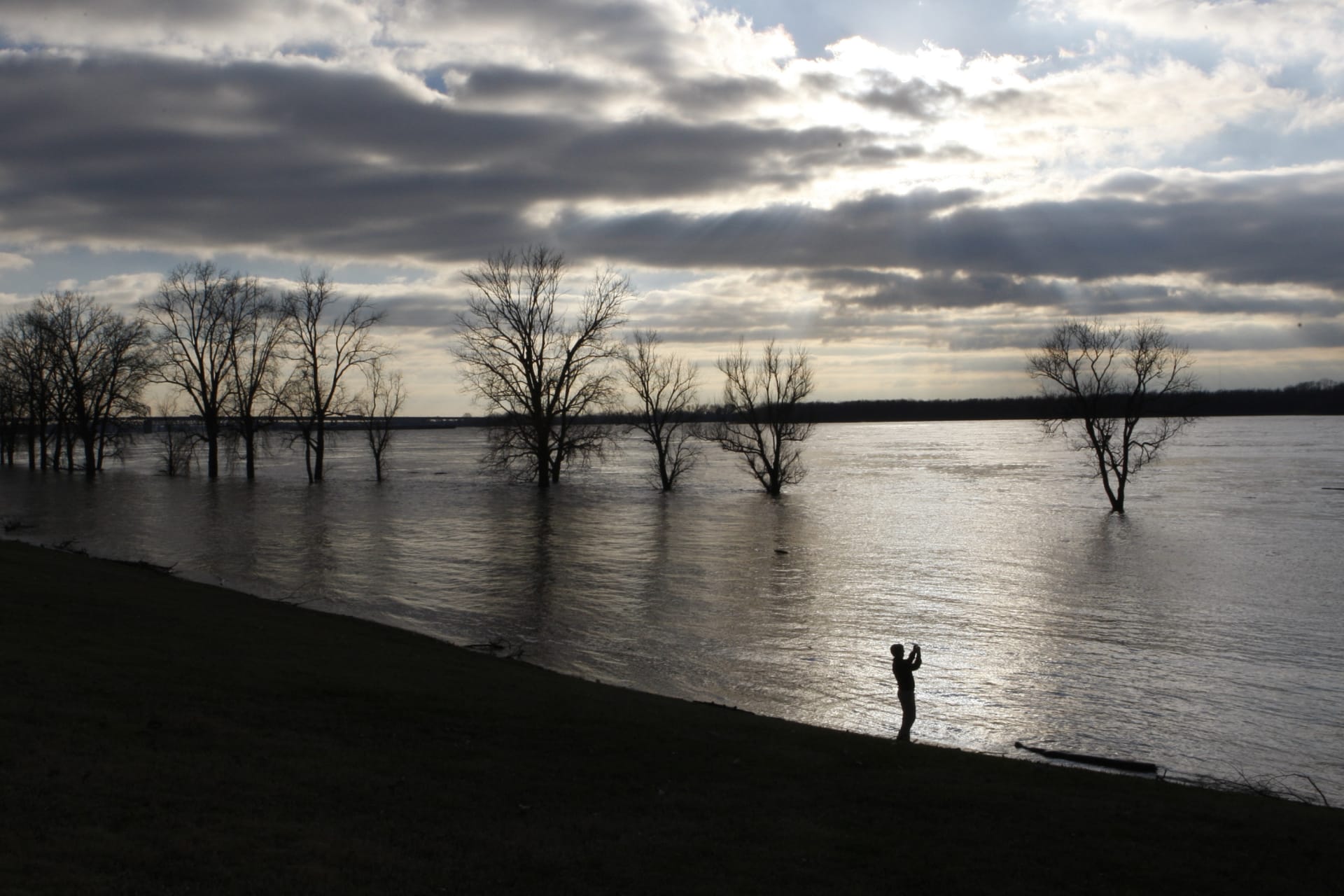 <p>Steve Sands takes pictures of the rising waters in the Mississippi River as flood waters approach their crest in Greenbelt Park in Memphis, Tennessee, on January 4, 2016.</p>