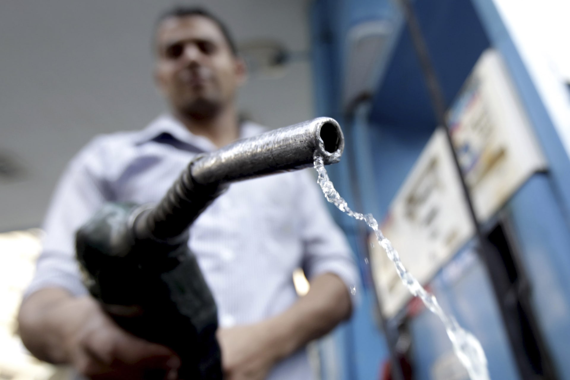 <p>A worker holds up a fuel pump nozzle after filling up the tank of a car at a petrol station in Cairo on October 3, 2012.</p>
