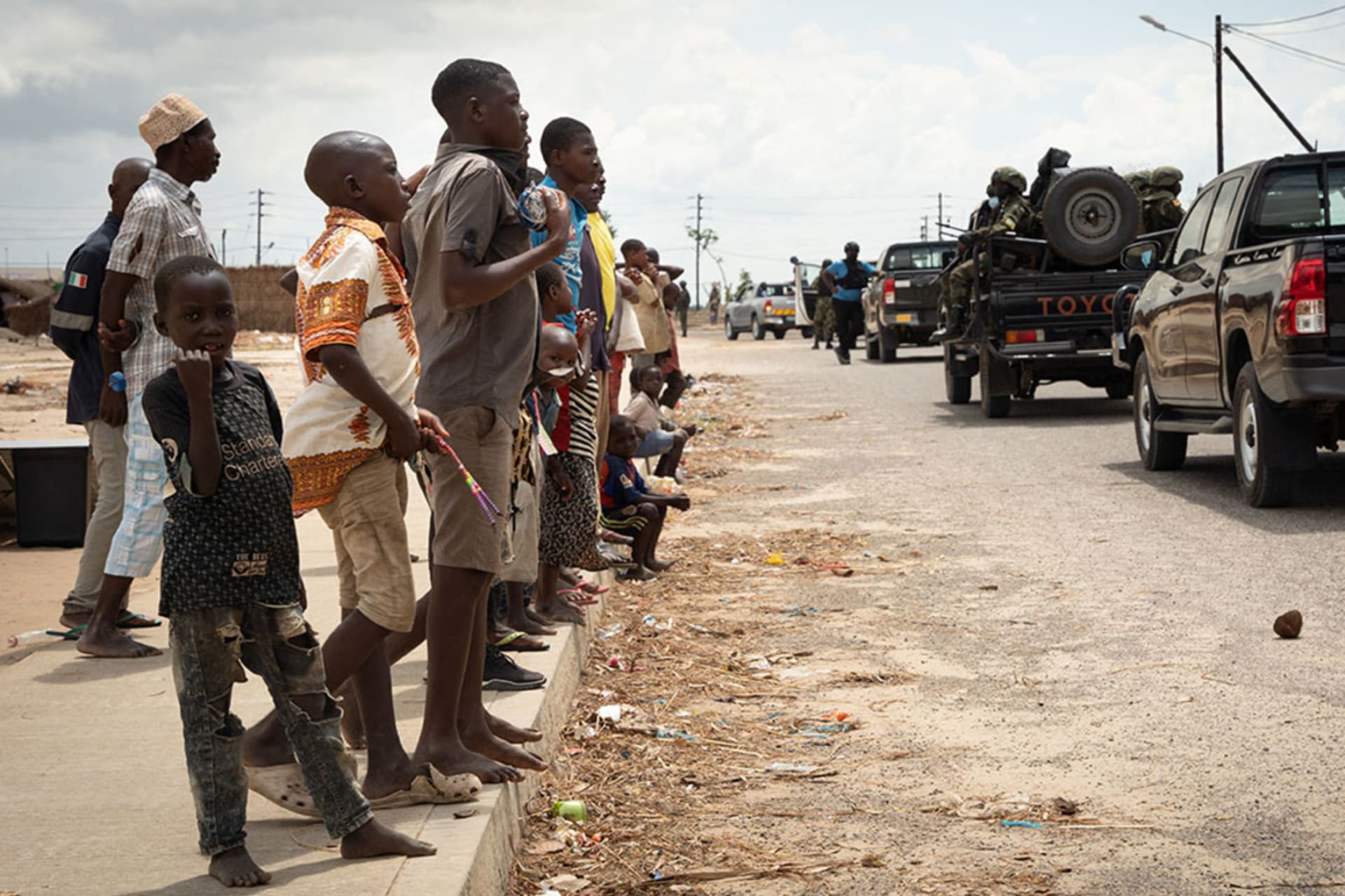 <p>Rwandan soldiers pass by Mozambican refugees at the Quitunda Camp in Afungi, Cabo Delgado, on September 22, 2021.</p>
