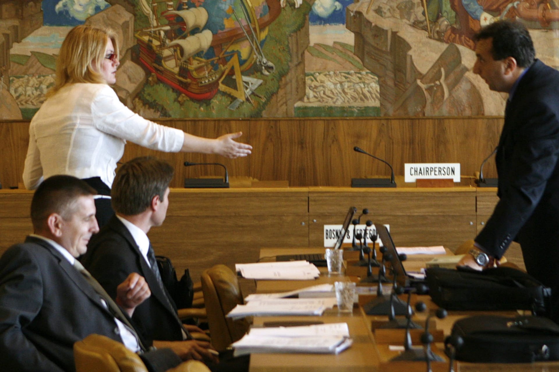 <p>Unidentified delegates talk in front of a Dean Cornwell mural painting made in 1938 in a meeting room at the World Trade Organization (WTO) headquarters in Geneva on July 18, 2008.</p>