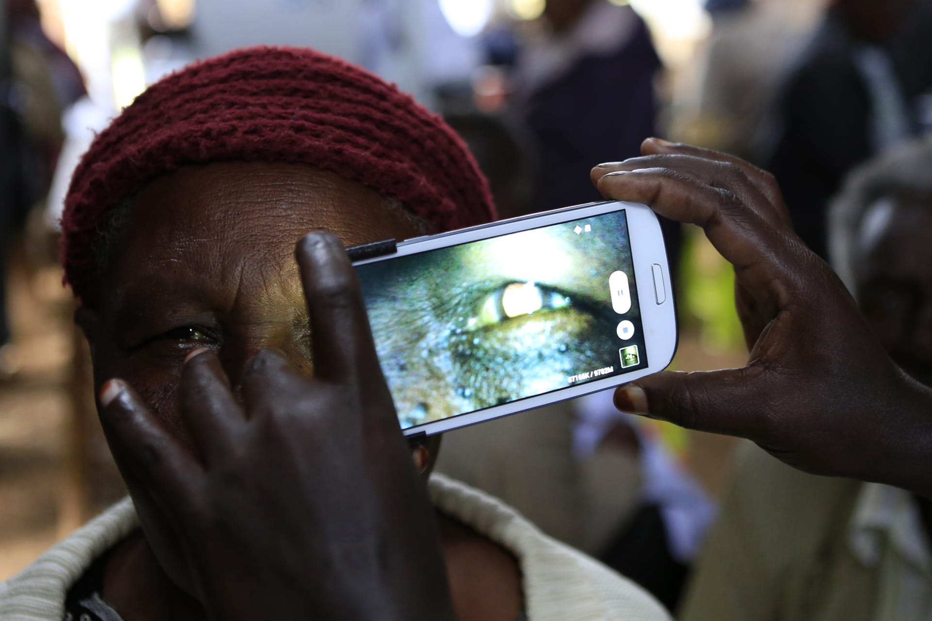 <p>A woman undergoes an eye examination using a smartphone at a temporary clinic by International Centre for Eye Health at Olenguruone in the Mau Summit 350km (217 miles) west of Kenya’s capital Nairobi on October 29, 2013. </p>

