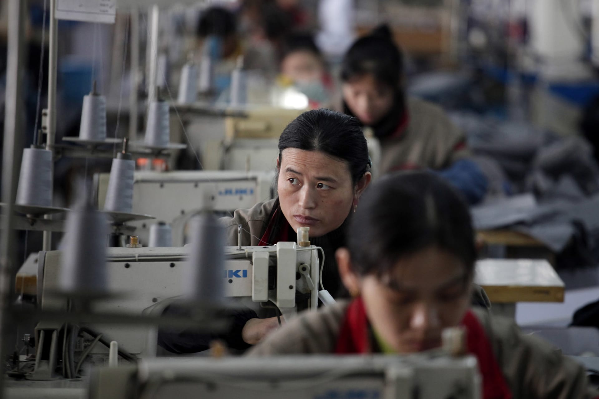 <p>An employee works at a clothes factory in Huaxi village, of Jiangsu Province, on December 3, 2010.</p>