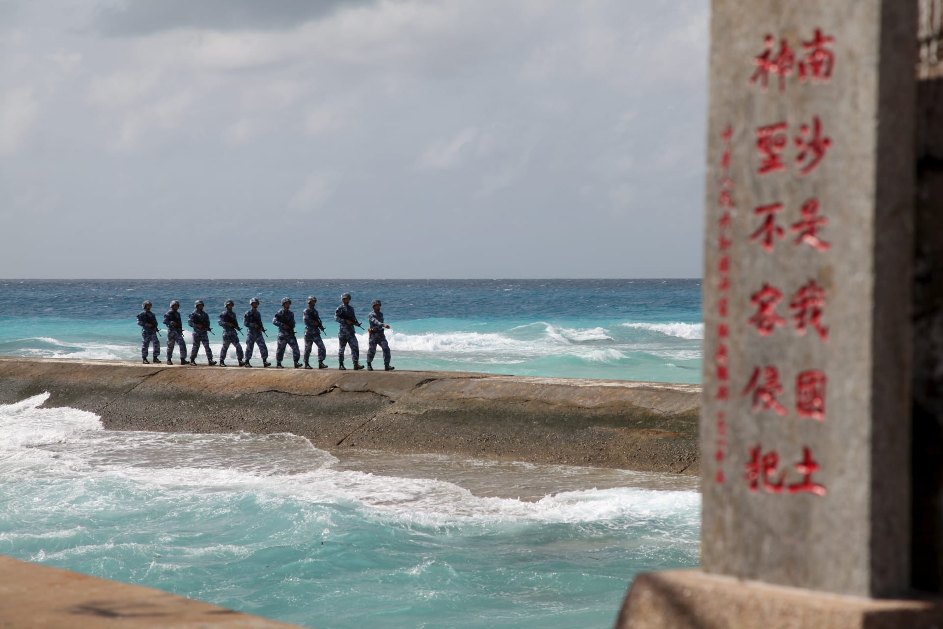 <p>Soldiers of China’s People’s Liberation Army Navy patrol near a sign in the Spratly Islands, known in China as the Nansha Islands, on February 9, 2016. The sign reads “Nansha is our national land, sacred and inviolable.”</p>
