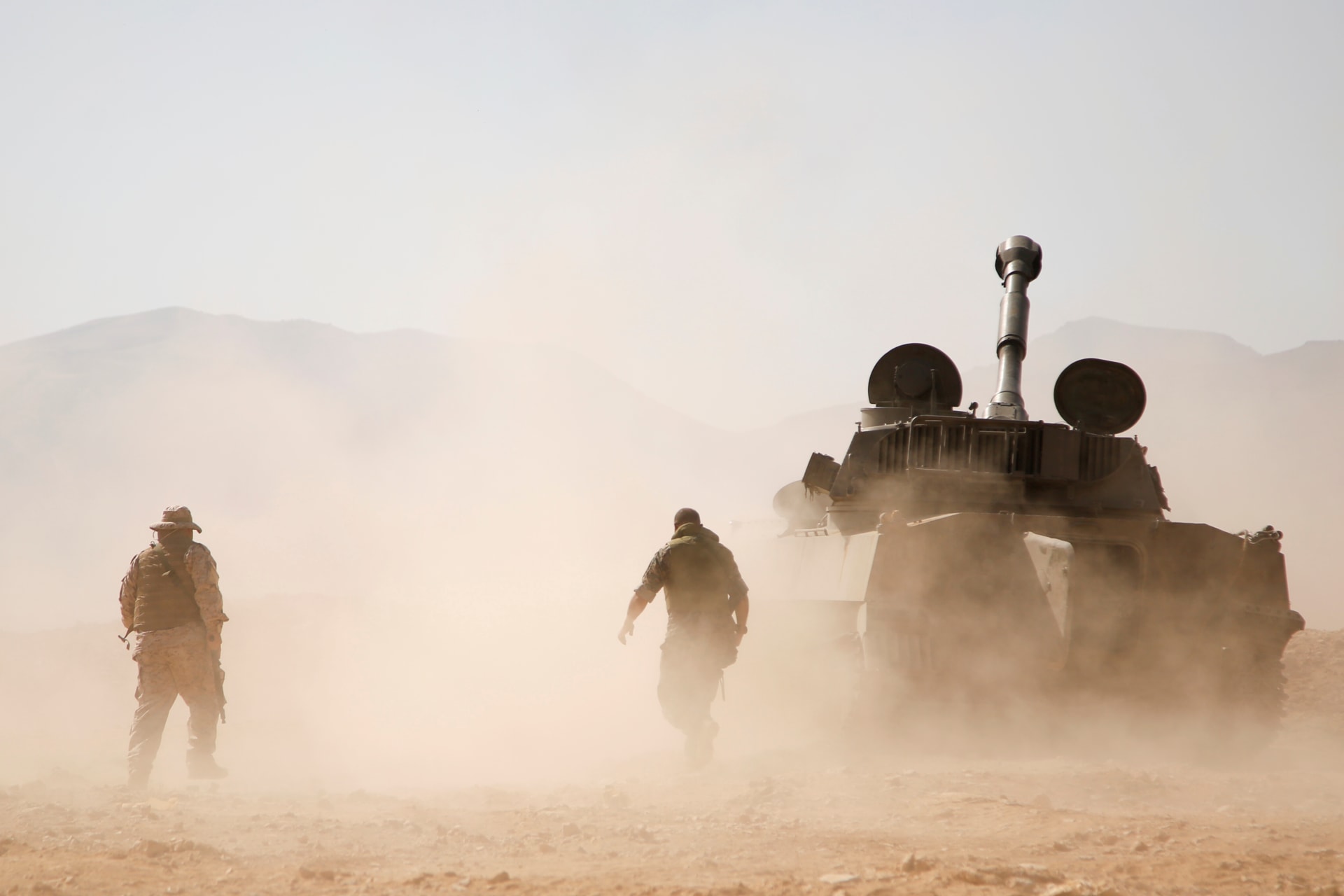 <p>Hezbollah fighters walk near a military vehicle in Western Qalamoun, Syria, on August 23, 2017</p>
