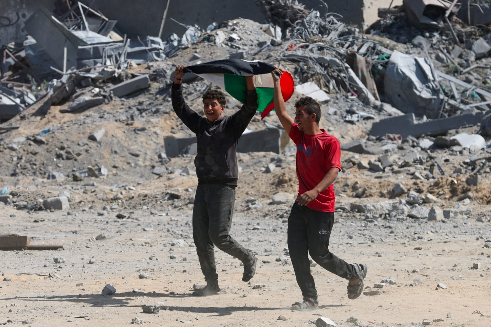 <p>Two Palestinian youth react to the news of the ceasefire between Israel and Hamas from Khan Younis.</p>
