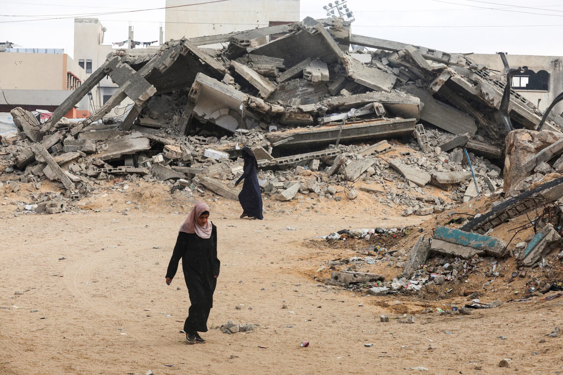 <p>Palestinian women walk near rubble in Khan Younis after U.S. President Donald Trump announced that Israel and Hamas agreed on the first phase of a Gaza ceasefire.</p>
