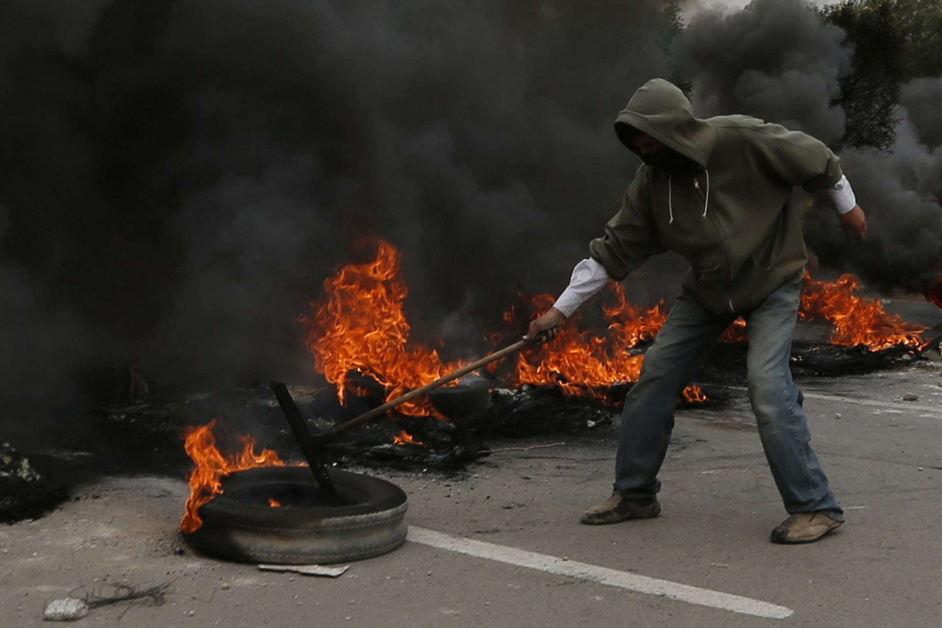 <p>A demonstrator blocks a street with burning tyres during a protest against fuel price hikes in Sanaa on July 30, 2014.</p>