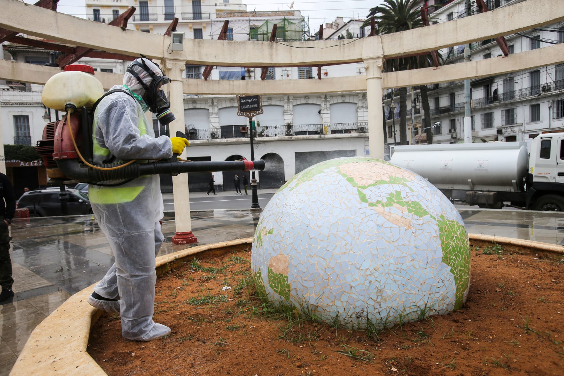 <p>A worker wearing a protective suit disinfects a globe-shaped public garden, following the outbreak of coronavirus disease (COVID-19), in Algiers, Algeria, on March 23, 2020. </p>