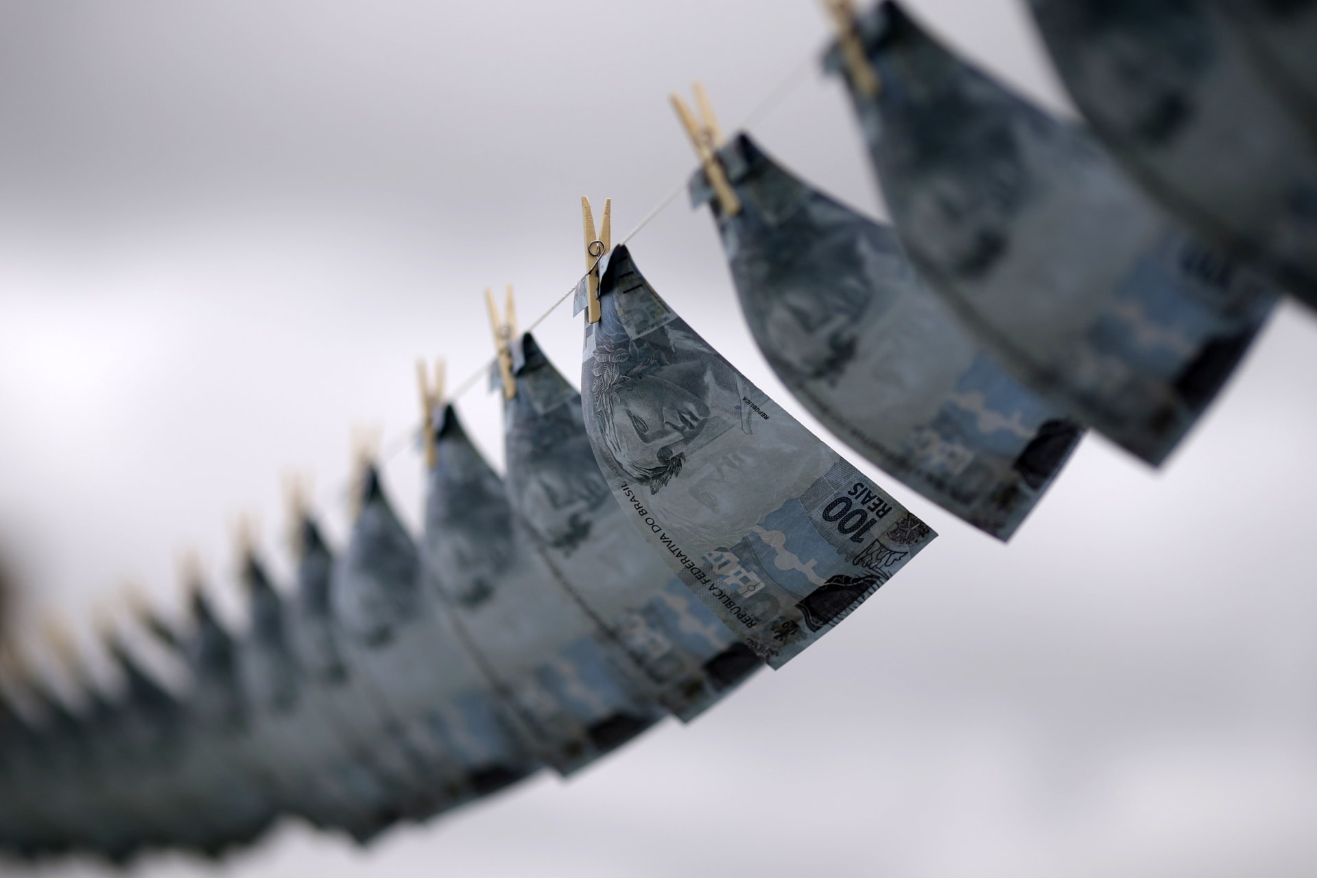 <p>Replicas of Brazilian banknotes are hung on a clothesline during a protest of the national union of prosecutors against money laundering in Brazil, at the Esplanade of Ministries in Brasilia, on March 18, 2015.</p>
