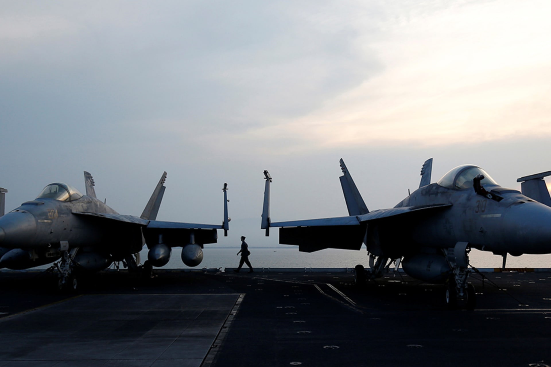 <p>A sailor walks behind aircraft on the U.S. Navy carrier USS Carl Vinson after it docked at a port in Danang, Vietnam, on March 5, 2018.</p>
