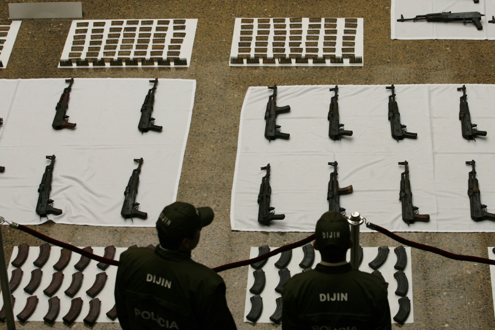 <p>Policemen stand next to confiscated weapons during a display for the press in Bogota on April 7, 2008.</p>