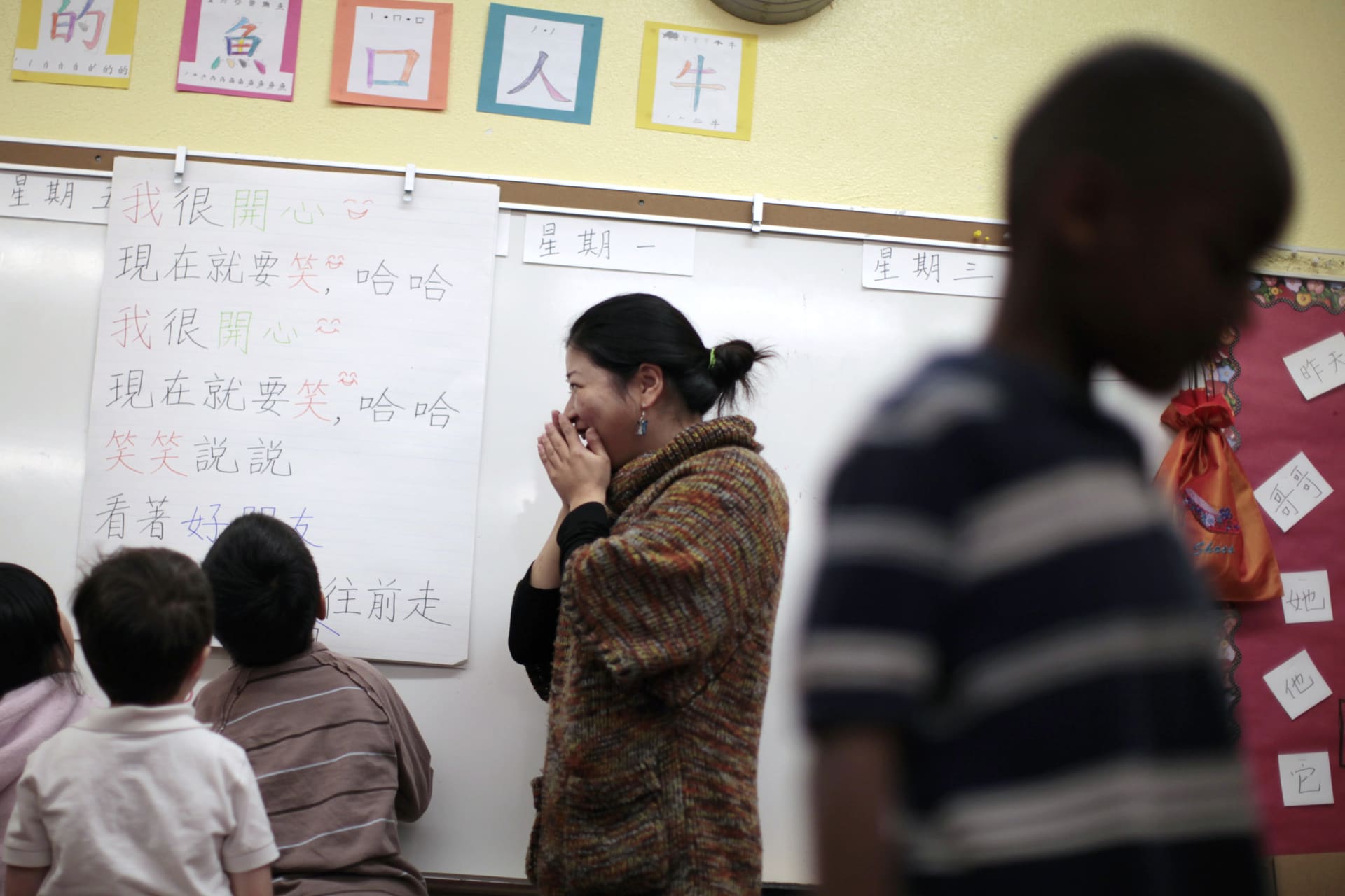 <p>Teacher Kennis Wong (2nd R) explains Chinese characters on a board at Broadway Elementary School in Venice, Los Angeles, California, on April 11, 2011.</p>
