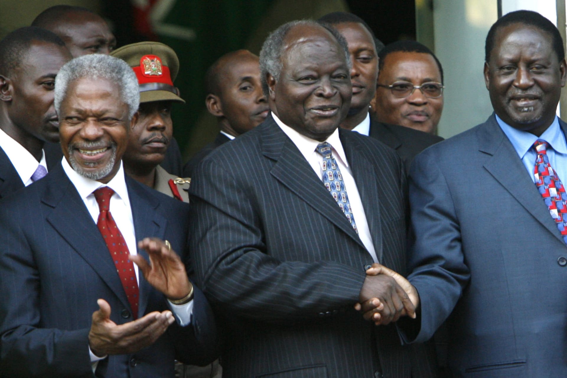 <p>Kenya’s President Mwai Kibaki (C) shakes hands with opposition leader Raila Odinga (R) as former U.N. chief Kofi Annan claps in Nairobi January 24, 2008.</p>
