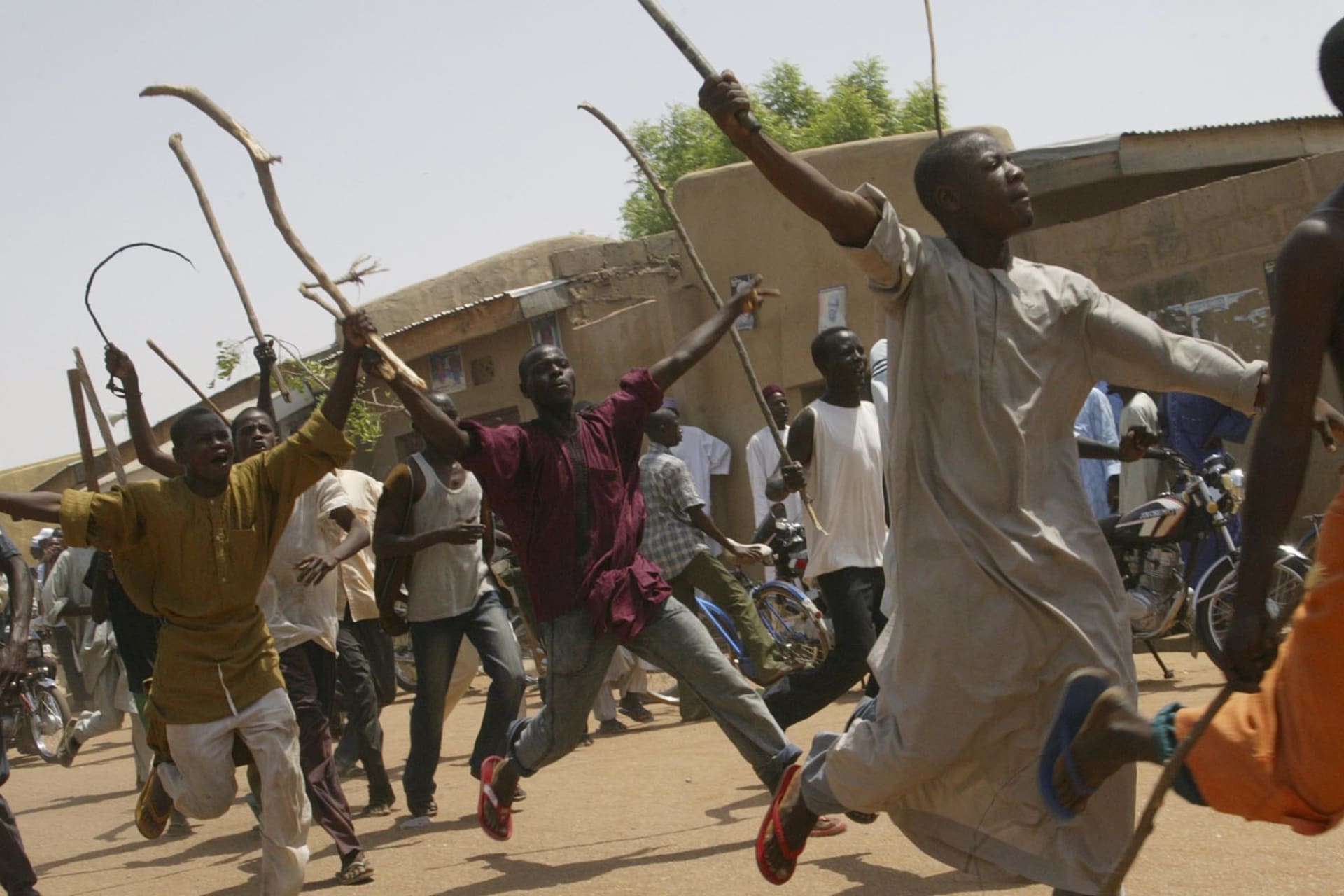 <p>Protesters run on the streets armed with wooden sticks to complain that the ballots did not arrive on time, in the northern town of Daura, on April 21, 2007.</p>