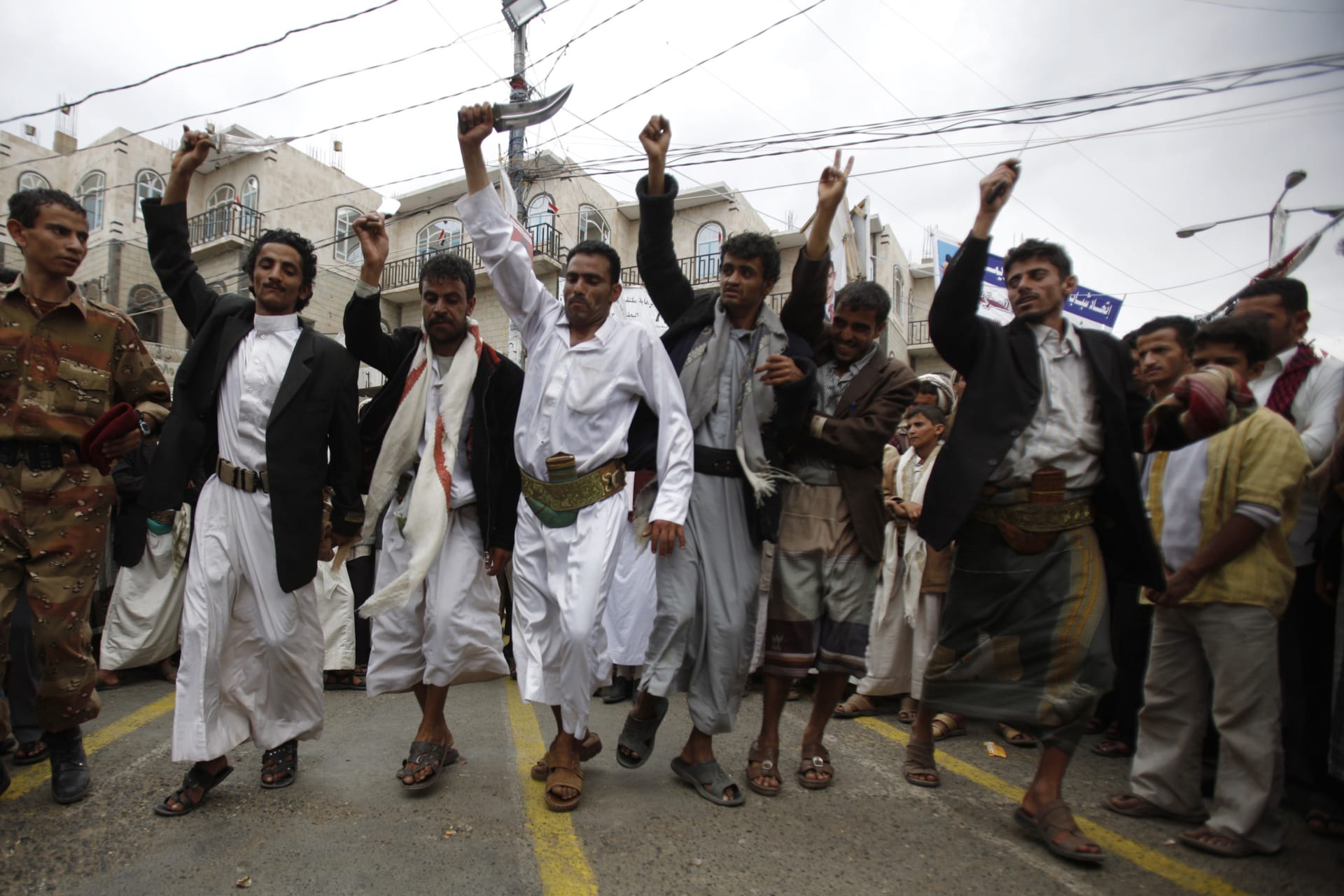 <p>A defected army soldier (L) and anti-government protesters wave daggers as they perform the traditional Baraa dance during a rally to demand the ouster of Yemen’s President Ali Abdullah Saleh in Sanaa on September 14, 2011.</p>
