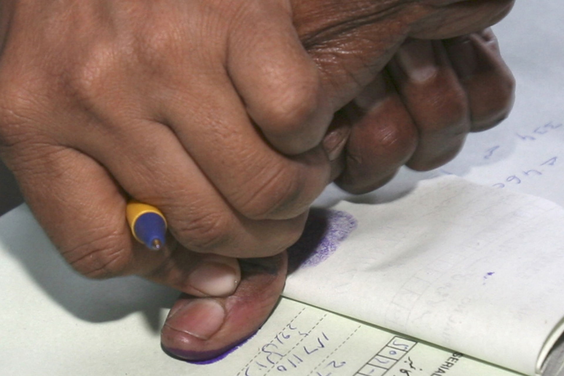 <p>A polling staff (L) gets the thumb print of a voter inside a polling station in Karachi on February 18, 2008.</p>
