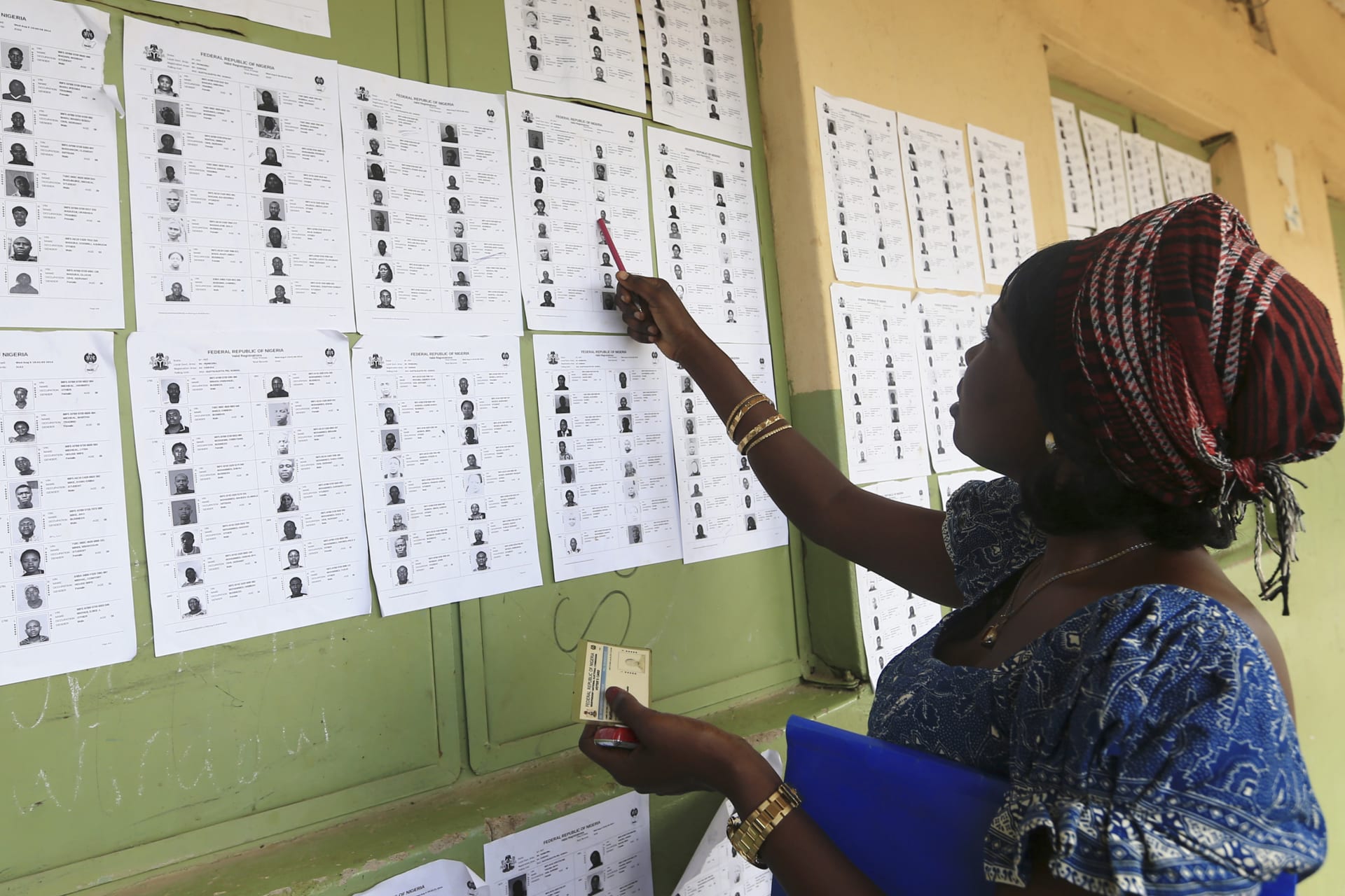 <p>A woman looks at a register of voters displayed at the Independent Electoral Commission (INEC) voters’ card collection centre in Aleita, Abuja, within the Federal Capital Territory (FCT) on August 19, 2014.</p>
