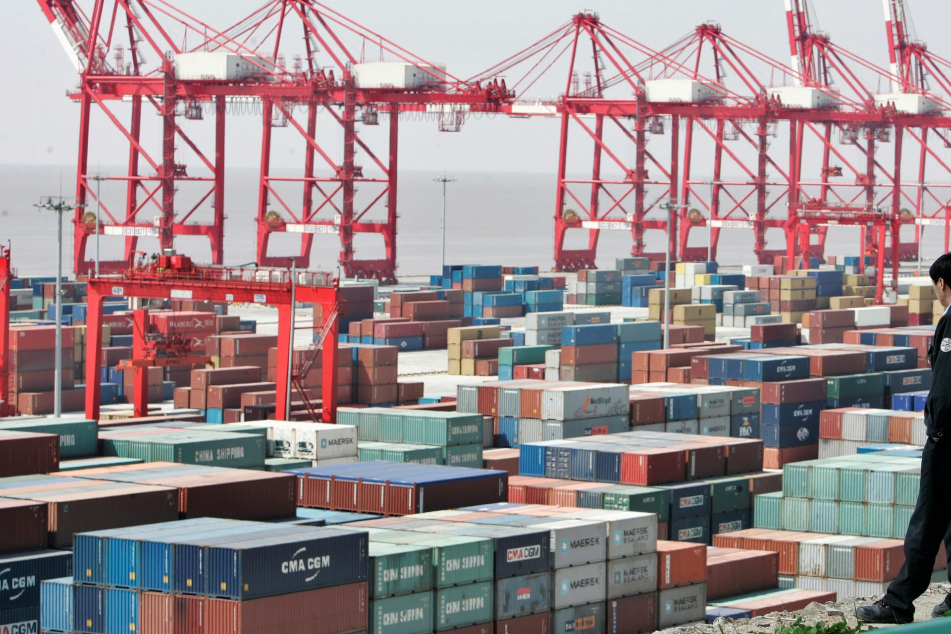 <p>A man watches containers at the Yangshan deepwater port in Shanghai on March 7, 2007.</p>
