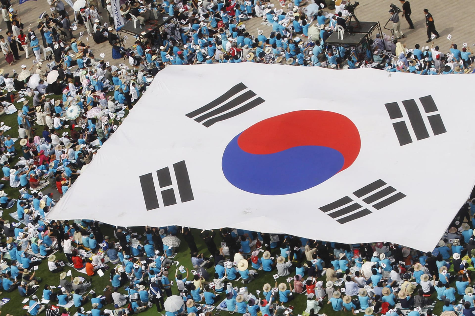 <p>People carry a large scale South Korean national flag during an anti-North Korea rally marking Memorial Day in Seoul on June 6, 2011.</p>
