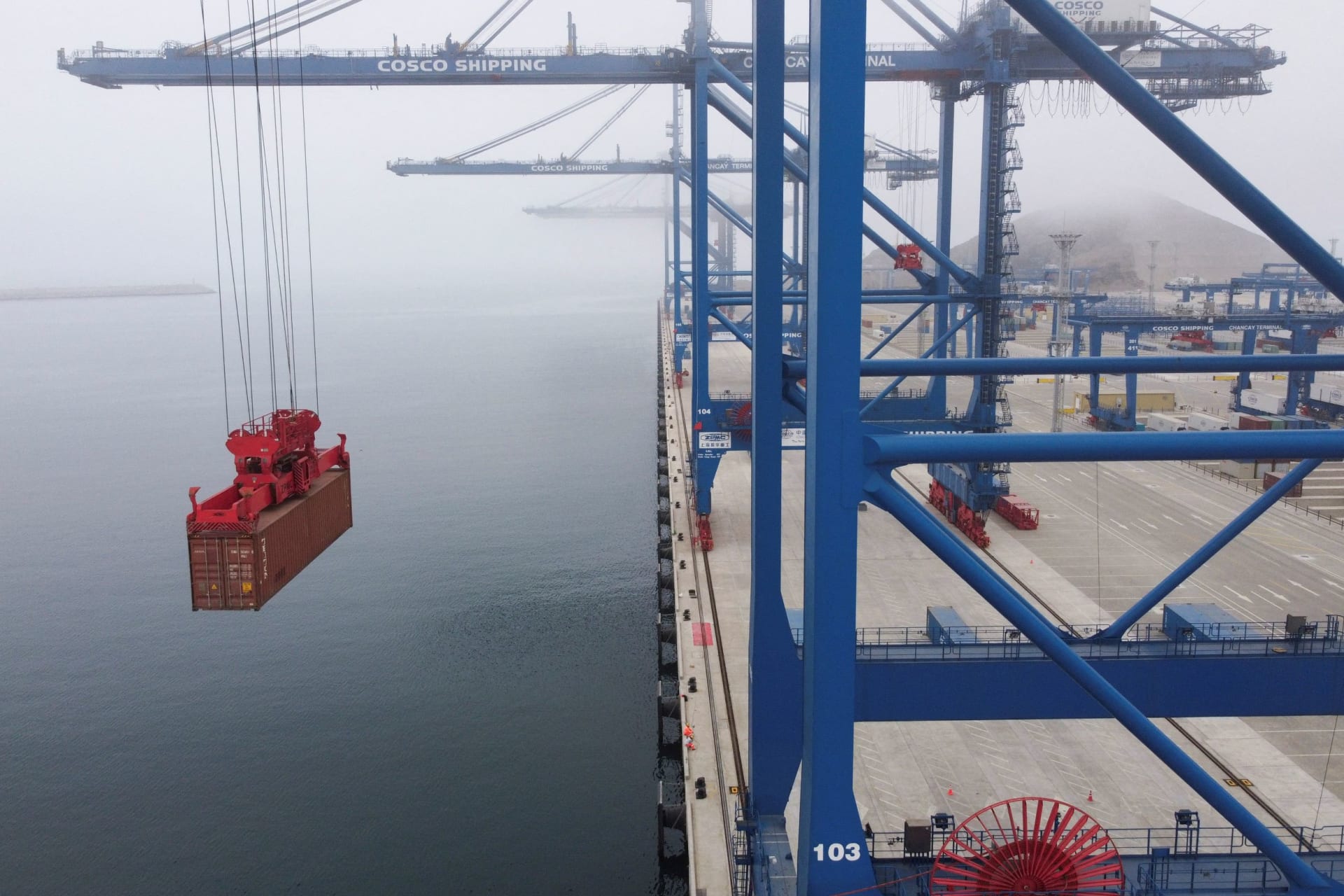 Drone view of crane moving a container at the Port of Chancay