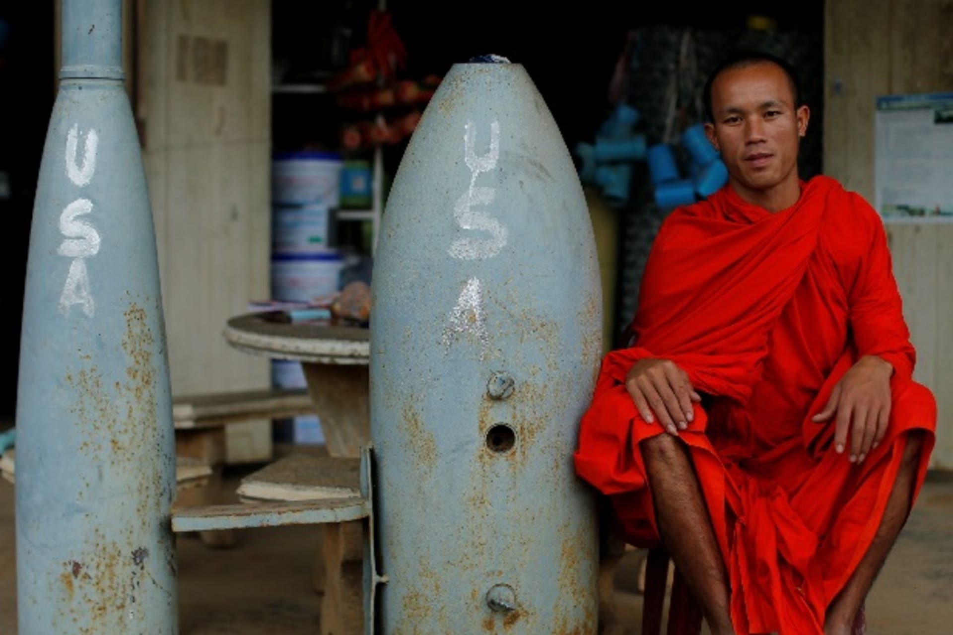 <p>A Buddhist monk poses next to unexploded bombs dropped by the U.S. Air Force planes during the Vietnam War, in Xieng Khouang in Laos September 3, 2016. </p>
