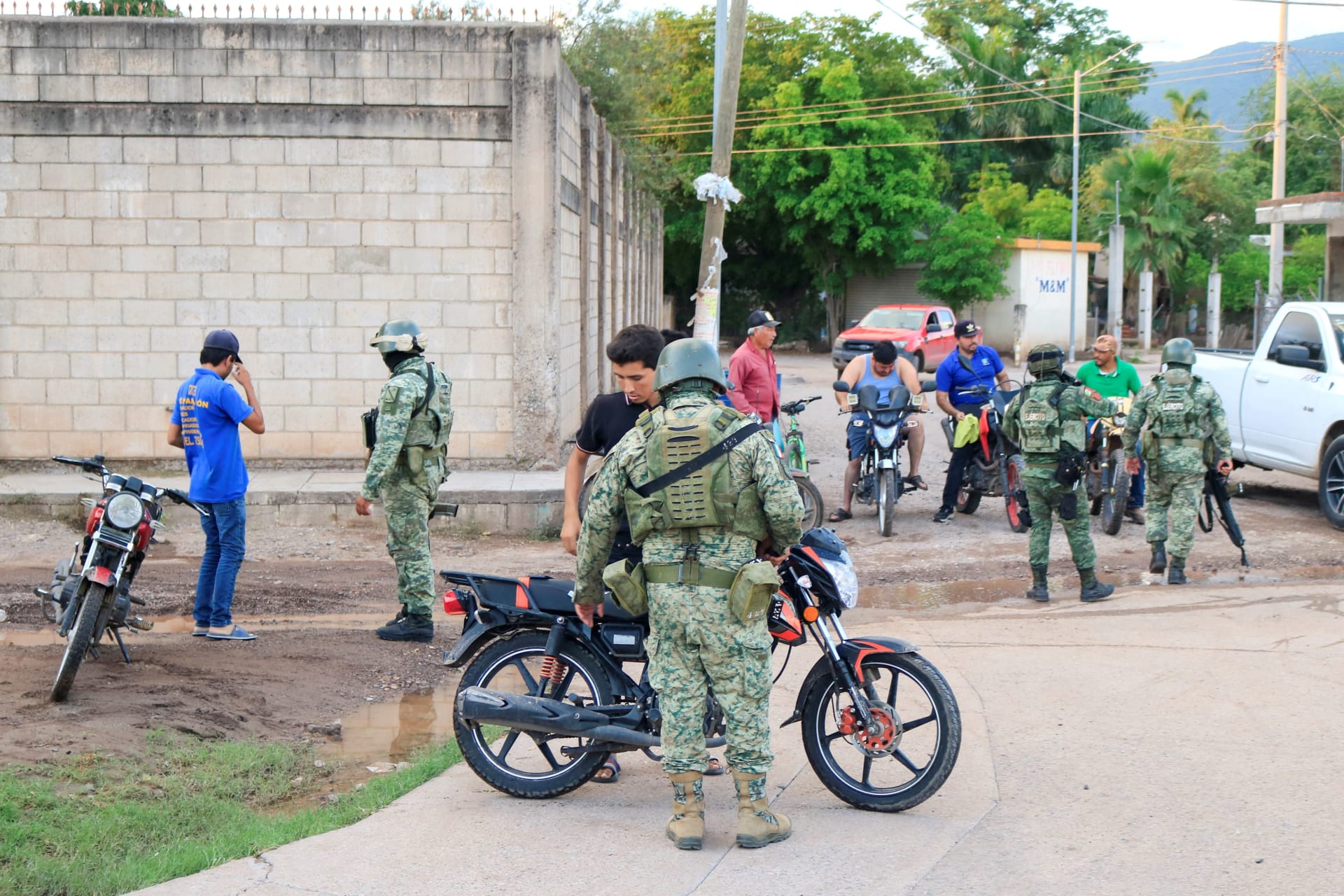 Photo of Mexican soldiers speaking to a group of men after a clash with cartel members in Culiacan.