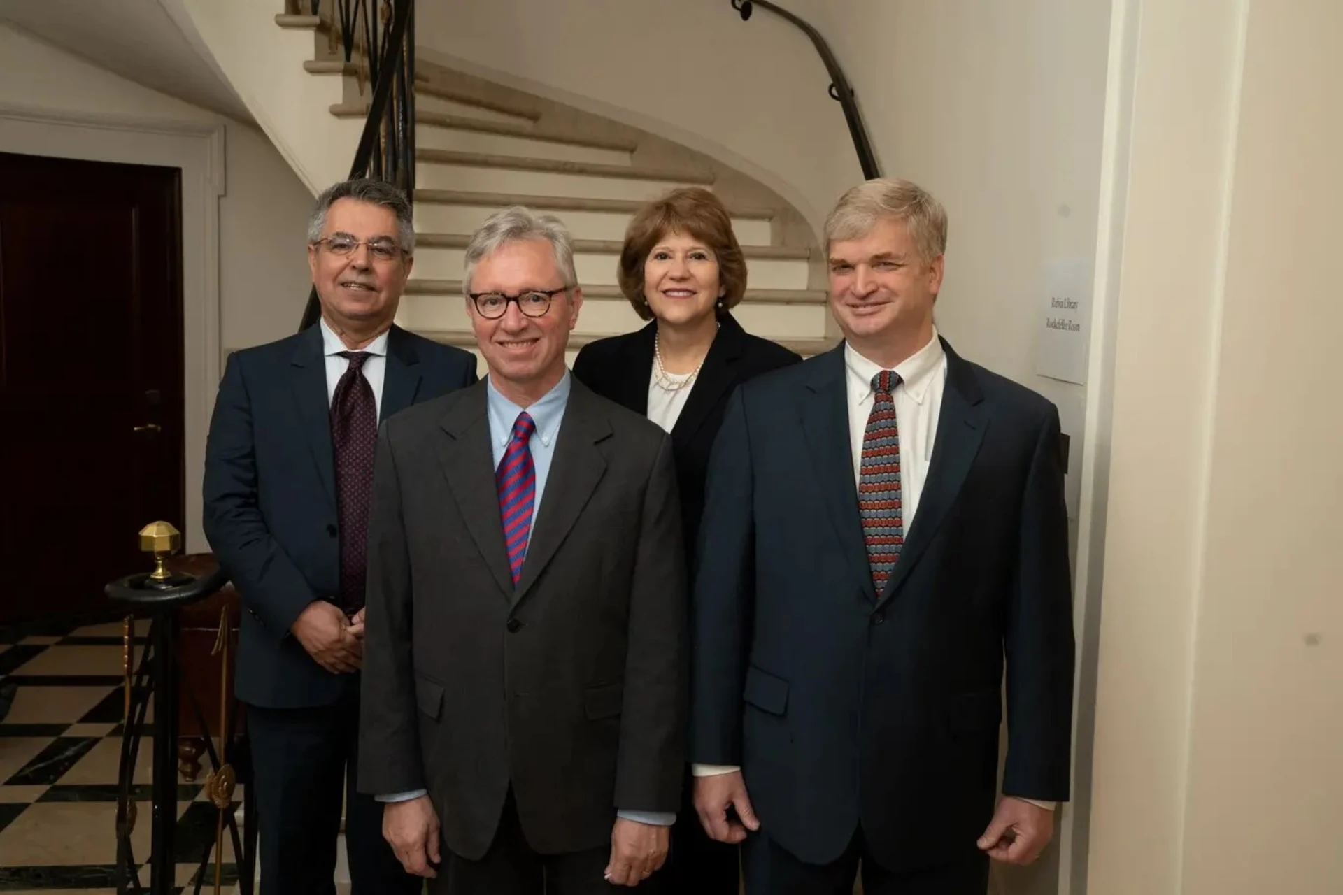 Photo of four people at the bottom of a marble spiral staircase.